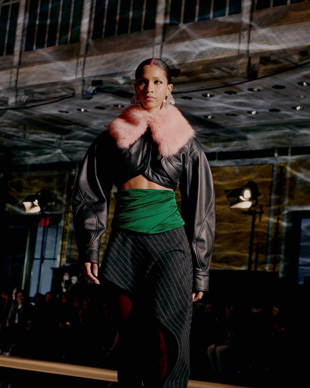 プラバルグルンのインスタグラム：「⁠Leather Weather⁠ ⁠ Black Leather Cropped Jacket with Repurposed Pink Shearling Collar with Emerald Hammered Satin Cummerbund and Black Pinstripe Wool Asymmetric Skirt from the Fall Winter 2023 collection⁠ ⁠ Photo by @vincenttullo」