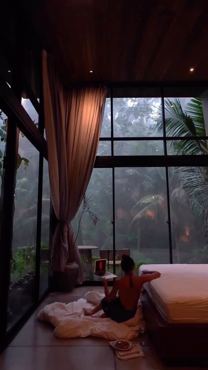PicLab™ Sayingsのインスタグラム：「Cozy season is upon us and this is our favorite way to spend a Sunday. 😌 Netflix & chill is even better when you’re in Bali! Ubud’s monsoon season is typically between the months of October - April with peak months having an average of 15+ rainy days a month! Right now the days remain sunny with a peaceful downpour in the afternoon. 🌧️   📌 @ubudzenriverhouse  🎥 @sabrina_diaries」