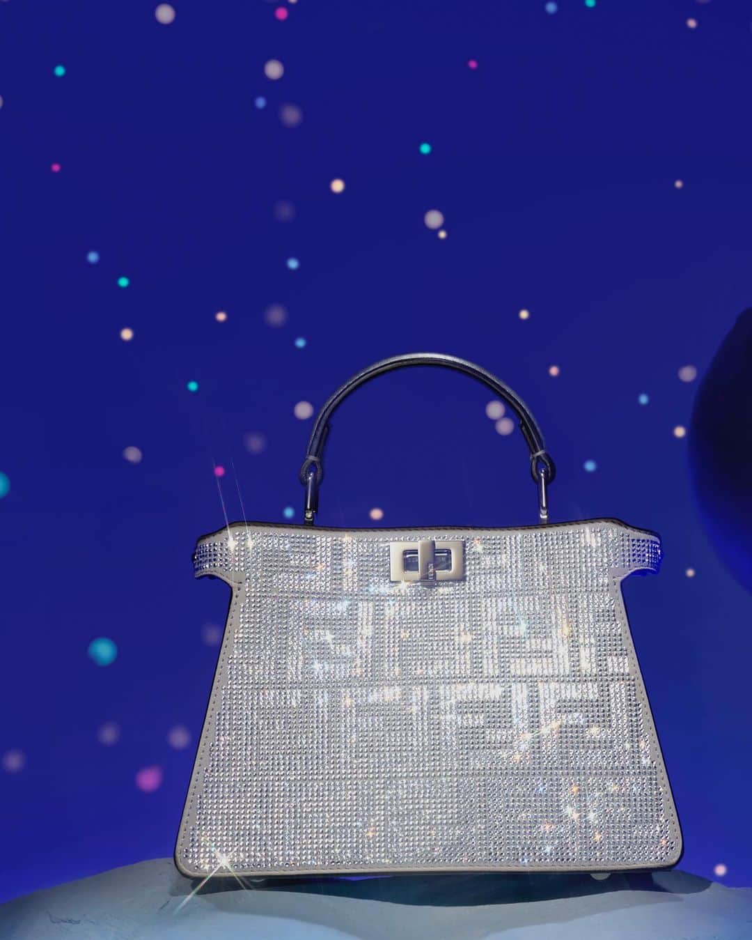 Fendiのインスタグラム：「Sparkling in multifaceted crystals, a special iteration of the #FendiPeekaboo lights up the Maison’s holiday campaign.  Shop #FendiGifts now in boutiques and at the link in bio.  Photography: @_miloreid_ Set Design: @tilly_power33」