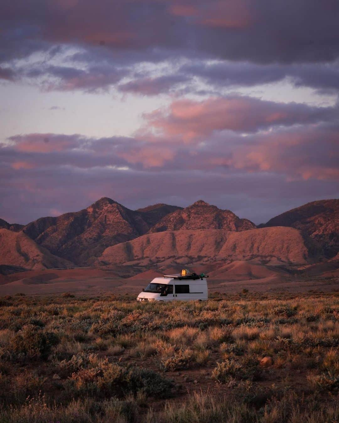 Australiaのインスタグラム：「Road trippin' never looked so good 😍🚙 This stunning shot by @betsysbiglap in @southaustralia is just one of many gorgeous scenes you'll come across in the ancient landscape of Ikara-Flinders Ranges National Park (@flindersrangesandoutback) 💕 An essential stop on your drive through the region is @wilpenapoundresort, where you can explore the beauty of Adnyamathanha Country alongside a local Traditional Custodian, and spend your evening glamping in style beneath the stars 🌠 Be sure to visit @prairiehotel to share a meal with the locals in an iconic #Aussie outback pub 🍴   #SeeAustralia #ComeAndSayGday #SeeSouthAustralia #FlindersRanges  ID: a white camper van is centred in a rocky outback landscape, tinted purple by a post-sunset sky.」