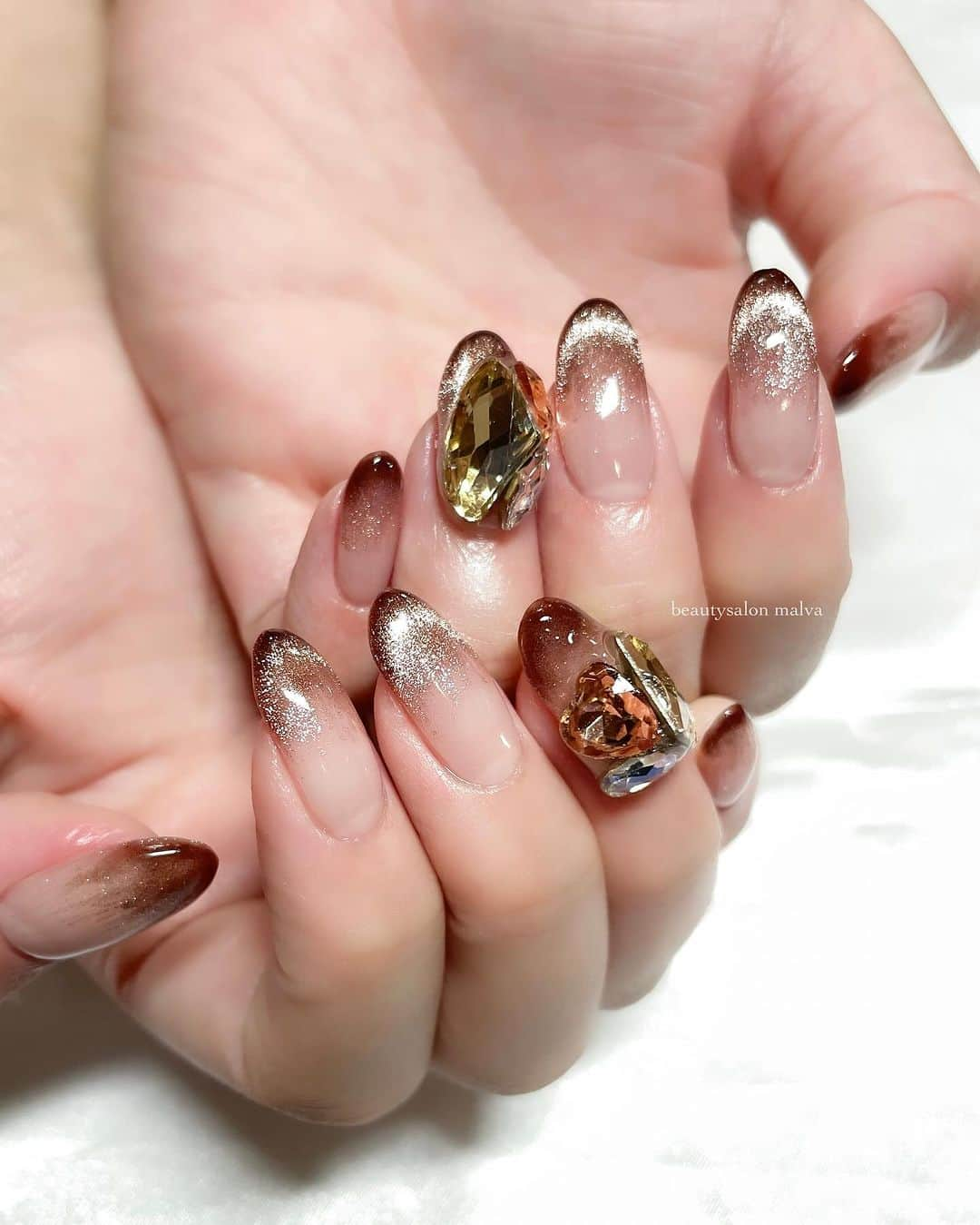 nailsalon malva（ネイルサロンマルヴァ）のインスタグラム：「【ベーシックプラス138】でご予約可能✨ マグネットネイルに大きなビジューアートが存在感大！！ シンプルなネイルも一癖したい方にオススメです🙆‍♀️ ⁡ ↪︎ ネイルのケアと保証期間 ⁡ malvaのネイルはドライケア、カットスタイルも込みです。 保証期間は約4週間となります（※ご新規様は3週間となります）。 ⁡ ＿＿＿＿＿＿＿＿＿＿＿＿＿ ⁡ ⁡ 𝐛𝐞𝐚𝐮𝐭𝐲𝐬𝐚𝐥𝐨𝐧 𝐦𝐚𝐥𝐯𝐚⠀ 📍明治神宮前駅｜原宿駅　徒歩𝟑分 ⠀ 💬ご予約やお問い合わせ 𝐋𝐈𝐍𝐄から承っております @ 𝐦𝐚𝐥𝐯𝐚 ⁡ お気軽にご連絡ください♡ ⁡ ⁡ ＿＿＿＿＿＿＿＿＿＿＿＿＿＿ ⁡ ▸ジェルネイル｜スカルプ｜ネイルケア ▸まつげカール｜まつげエクステ｜ワンホンエクステ ▸ハーブよもぎ蒸し ▸ワックス脱毛 ⁡ \ アシスタント募集中💁‍♀️ / ⁡ ▸リモート可オンラインの画像動画制作アシスタント ▸サロンワーク全般アシスタント ⁡ ⁡ #冬ネイル2023 #マグネットネイル #ビジューネイル　#ブラウンネイル #malva #malvaネイル  #シースルーネイル  #原宿ネイル #透け感ネイル  #表参道ネイル #東京ネイルサロン　#明治神宮前ネイル #新宿ネイル #千駄ヶ谷ネイル  #harajukunails #tokyonails #tokyonailsalon ⁡」