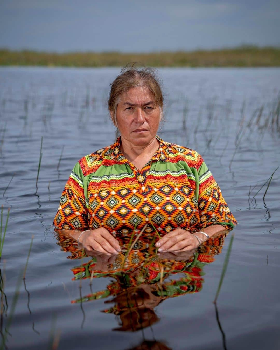 ナショナルジオグラフィックのインスタグラム：「Photo by @carltonward | Betty Osceola is a member of the Miccosukee Tribe of Indians of Florida, an airboat captain, and a powerful advocate for her Everglades home. As we mark Native American Heritage Month in November, I am grateful for her willingness to share her native lands with me and the world, including in her role as a lead character in the National Geographic film "Path of the Panther," now streaming on @disneplus.The Seminole and Miccosukee are the last Native Americans living in Florida.   Betty Osceola advocates for better and more equitable management of Everglades water. She is asking the Army Corps of Engineers to open all the floodgates along the Tamiami Trail—a 264-mile stretch of highway between Miami and Tampa—that are currently holding back water and drowning her ancestral lands. Roads, drainage canals, and development have been blocking and diverting the flow of Everglades water for the past century. The Tamiami Trail in particular has served as a dam blocking the water. South of the road, Everglades National Park has been deprived of water that once flowed seamlessly from the north, and north of the road, Miccosukee tribal lands have been drowning under too much water artificially held back by the road and by water management practices that have prioritized flood control for densely populated areas closer to the coast. During that time, 70 percent of the tree islands that Osceola and her people have historically relied upon and which have great cultural significance for the Miccosukee, have been lost.   Through new Everglades restoration efforts, several miles of the Tamiami Trail have been elevated into bridges to help rebalance the flow of water. But more work is needed in the multiyear restoration plan, with continued investment from the U.S. and Florida governments, in order for water to flow more naturally and for the ecosystem to more fully recover. #NativeAmericanHeritageMonth」