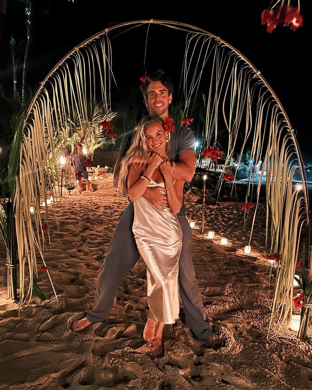 ニオミ・スマートのインスタグラム：「If I could dream up the most romantic evening together it would be this. Toes in the sand with the sound of the waves, lit only by stars and candle light, surrounded by hibiscus flowers. Oh, and the most mouth watering food I’ve had in a long time! Thank you @nihi for pulling out all the stops and making this so special and memorable. (Definitely would’ve been on the edge of my seat if we weren’t already engaged 🤣💍)」