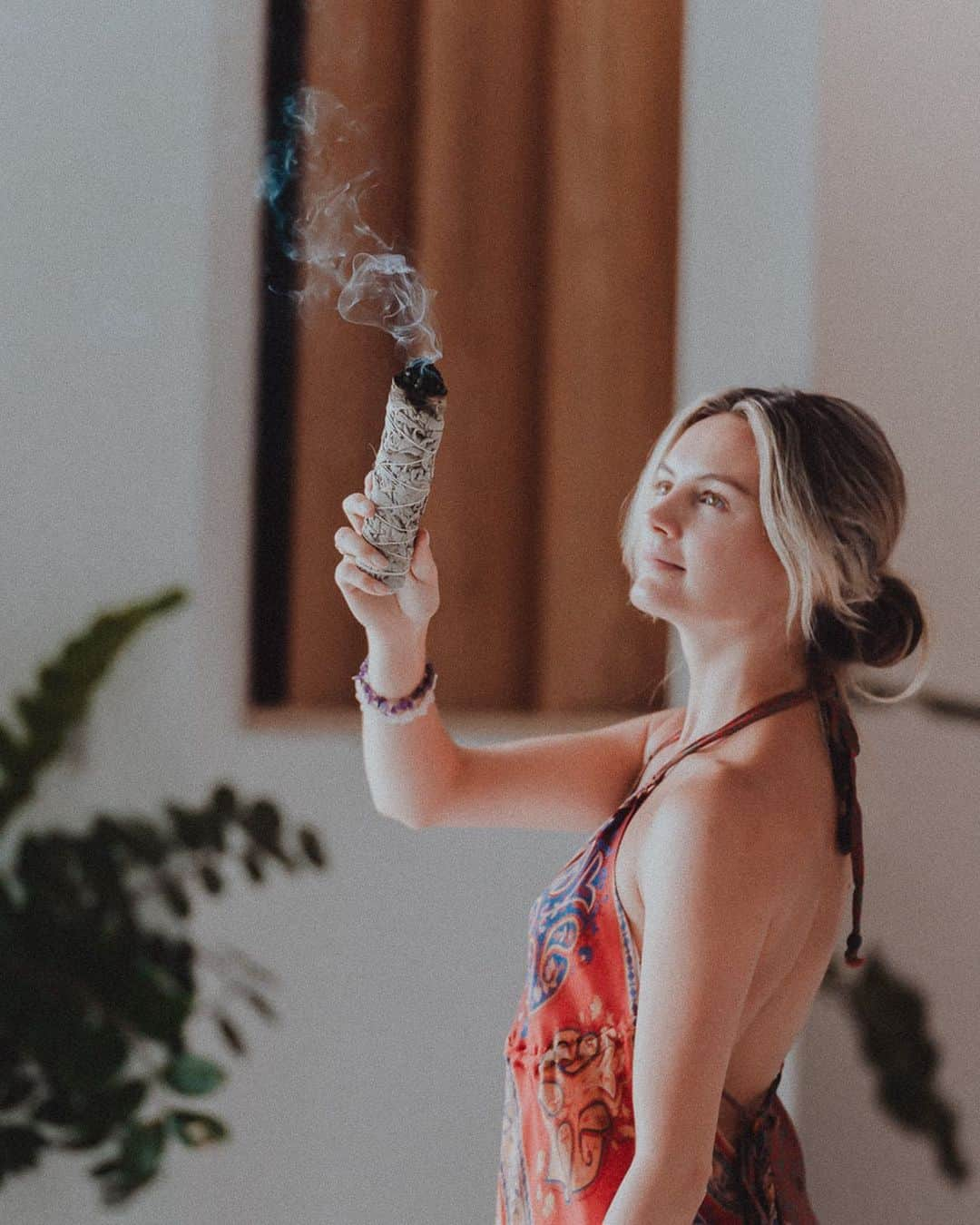 ニオミ・スマートのインスタグラム：「Sage is like a personal protective bodyguard. Cleansing / smudging is a way to show negative energy the door. I do this as often as feels necessary, but especially when I’m staying in a new space to rid of the previous stagnant energy that may be stuck and to start afresh.   I’ve started verbalising this ritual out loud too, asking the unwanted energy to leave to create more space for light and love. I love the idea that we have the power and magic to create desirable spaces using an abundance of tools available to us and within us - our inner world reflects our outer world.  This year has felt heavy in so many ways, but finding small yet purposeful rituals throughout our day can make a difference in shifting the heaviness. These practices aren’t a quick fix, but they can help our personal energy and mindset... and help protect us! See last two posts 😆.   While I cleanse I also light candles, incense, play soft complimenting music, and consciously prepare the room for peace.  It may look or sound woo woo, but I often think what’s to lose? Yes, people may think it’s pointless or crazy, but if you feel a positive impact from certain practices, does it really matter what others think? Who wants to be normal anyway… that just means doing what everyone else is doing!   Stay open and curious, always 🌟.」