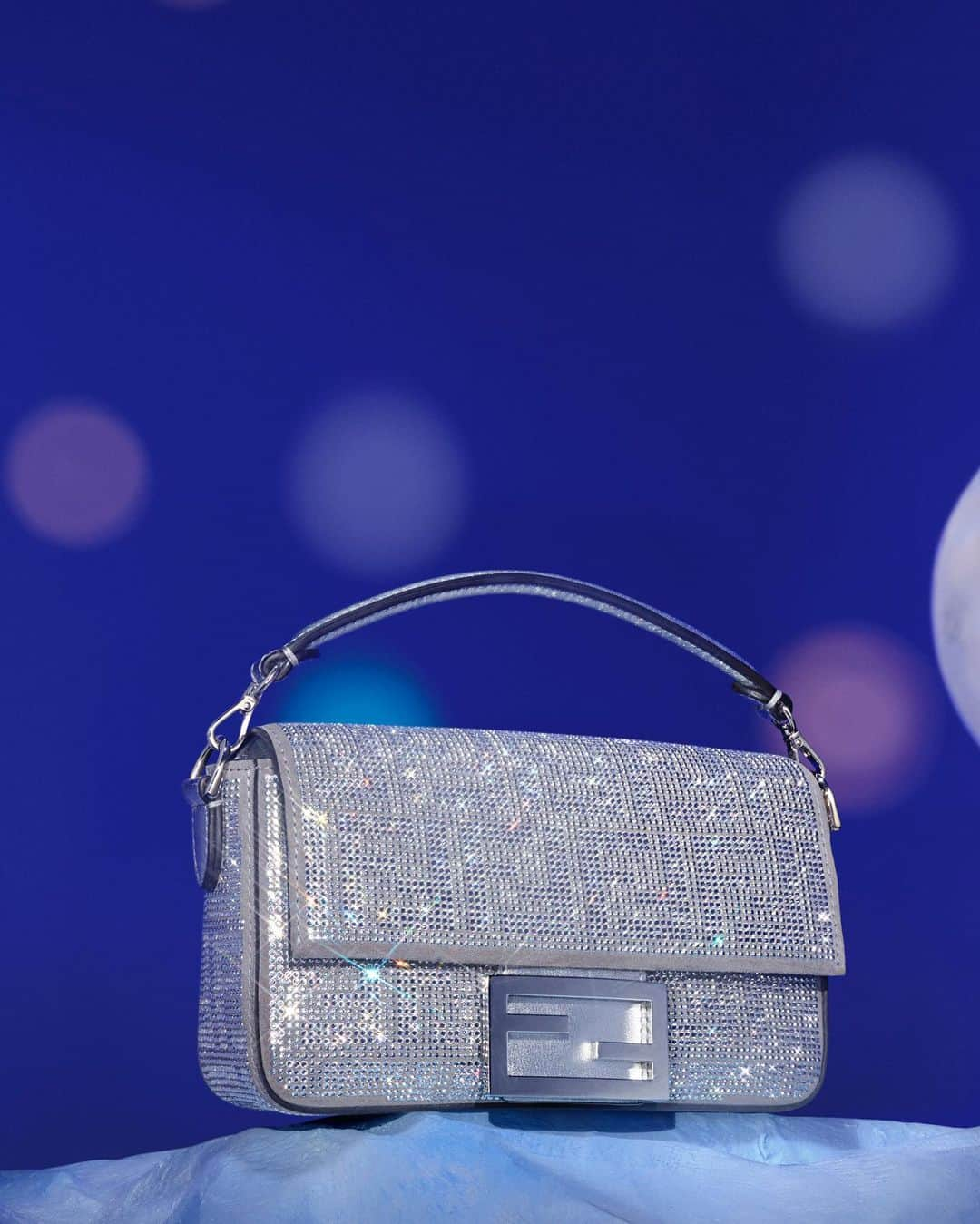 Fendiのインスタグラム：「Multifaceted crystals are expertly positioned to form the heritage FF motif across the #FendiBaguette and #FendiPeekaboo in the Maison’s gift selection.   Discover #FendiGifts in boutiques and at the link in bio.  Photography: @_miloreid_ Set Design: @tilly_power33」