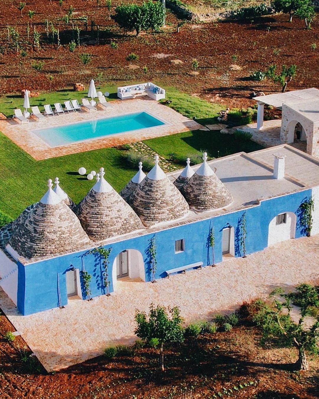 BEAUTIFUL HOTELSのインスタグラム：「Immerse yourself in the enchanting Itria Valley, where tradition meets innovation in the stunning @apuliaria villas. 🏡 Eight renovated trulls, adorned in a charming blue color palette, perfectly complement the traditional trulli cones, creating a serene getaway in the heart of Puglia. 🇮🇹✨  📽 @apuliaria 📍 @apuliaria, Puglia, Italy」