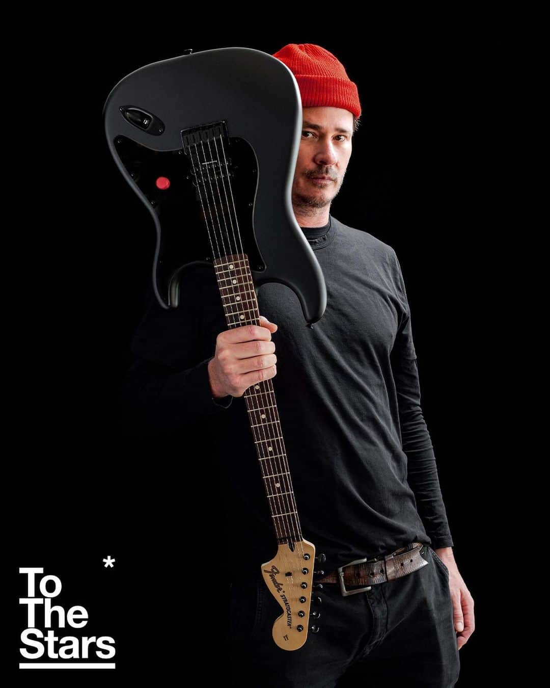 トム・デロングのインスタグラム：「Introducing the exclusive To The Stars* limited edition Tom DeLonge Signature Stratocaster in Blackout. We teamed up with our friends at Fender to release this special edition Strat decked out in all-black hardware with a satin black finish and simple pop of color with its single knob in TTS* signature red. This guitar also includes a Certificate of Authenticity signed by Tom and a custom hardshell case featuring the TTS* logo and Tom’s original signature artwork. Limited to 300 units worldwide, $1499.99. Pre-order begins at 9 AM PST this Black Friday, November 24, only at ToTheStars.Media.  📸: @fog.again   #tothestars #tomdelonge #fender #stratocaster #guitar」