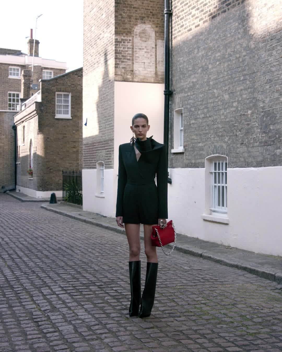 アレキサンダー・マックイーンのインスタグラム：「A black tailored tuxedo jumpsuit with a deconstructed orchid drape, worn with Shard boots and the #McQueenPeak bag in red.⁣ ⁣ Discover the #McQueenAW23 collection via the link in bio.⁣ ⁣ Photographed by @Jet.Swan⁣ Video by @EbbaHult⁣ Track: Neurons by @roblewiscomposer⁣ Music Director: John Gosling」