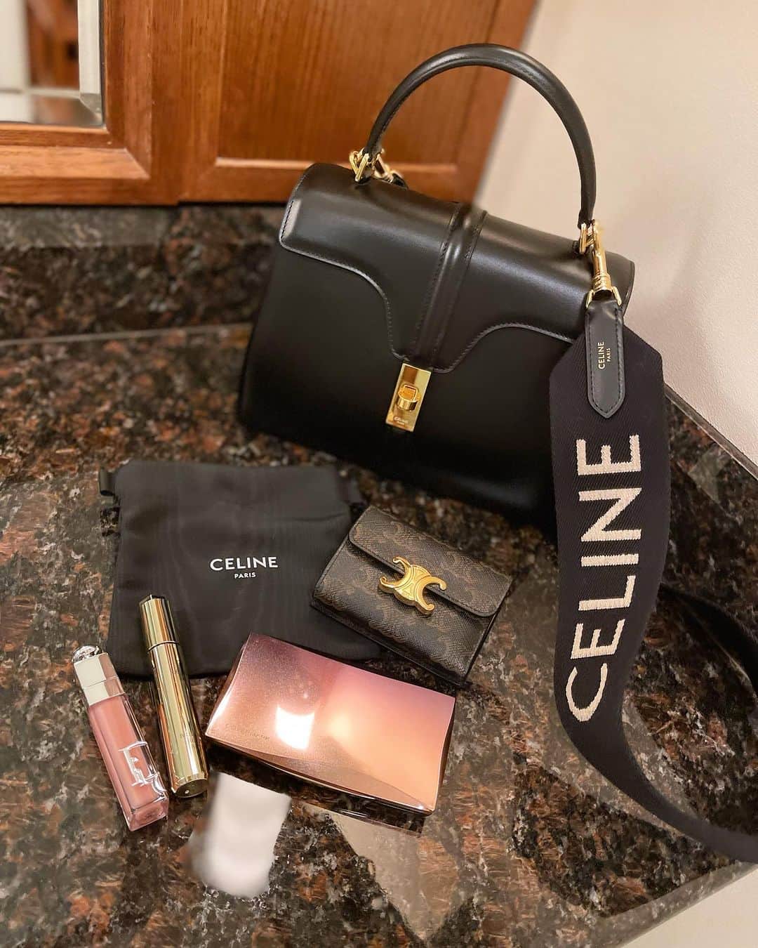 瀬戸早妃のインスタグラム：「お気に入りのカバンの中身👜 @celine   ほとんど何も入ってない…🥰  お財布とリップグロス2種 (DiorとESTEE LAUDER) あと傷跡隠しのフローレスフィット (COVERMARK)  メイクポーチも持ち歩かなくて CELINEでお買い物した時についてきた 保存袋を利用しています🖤  #カバンの中身 #バッグの中身 #紹介するほどでもない😂」