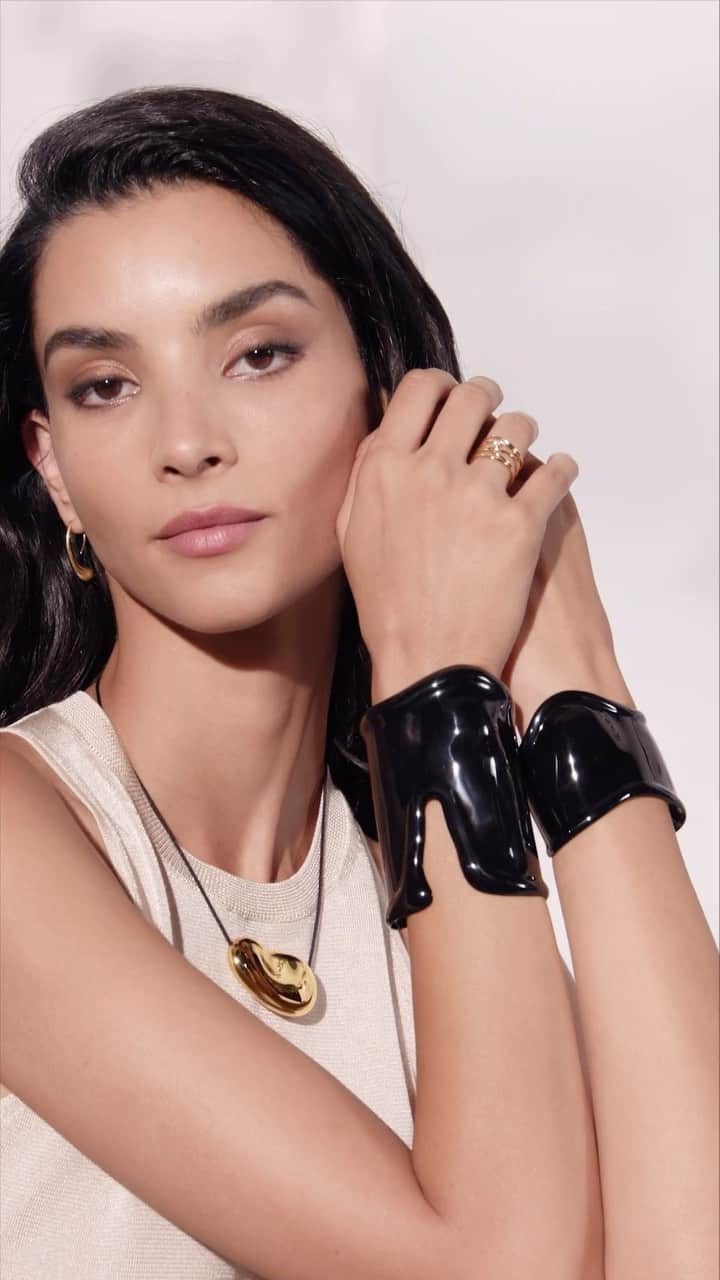 ティファニーのインスタグラム：「Mixing and matching has never looked better. Powerful femininity takes shape with bold Elsa Peretti® Bone cuffs in black—the perfect juxtaposition to the sensual contours of a warm, 18k gold Bean® design pendant. Link in bio. #ElsaPeretti #TiffanyAndCo」