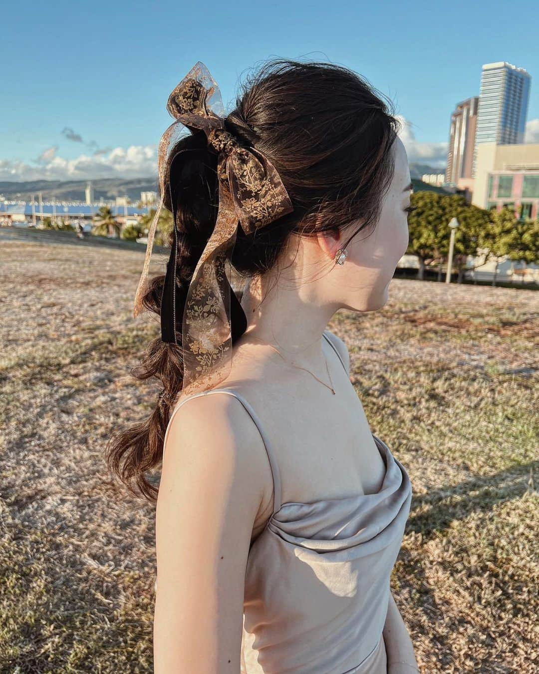 Yukari Ogayaのインスタグラム：「: Sunset ponytail style .  2種類のリボンでポニーテールアレンジ🎀 サンセットは、可愛いんだけど、どこか大人っぽくも🥀 リップは濃いめのカラーを合わせるとグッとオシャレに。 私も最近濃いめ好き🤎 . Hair& makeup by @yukariogaya  . . . .  #2023 #thisisyukaristyle #hawaiiwedding  #destinationwedding  #bridehair  #bridalmakeup  #weddinghairstyles  #updospecialist  #ハワイウェディング #海外ウェディング #花嫁ヘア  #花嫁ヘアメイク  #海外花嫁 #ヘアアレンジ  #ハワイヘアメイク」