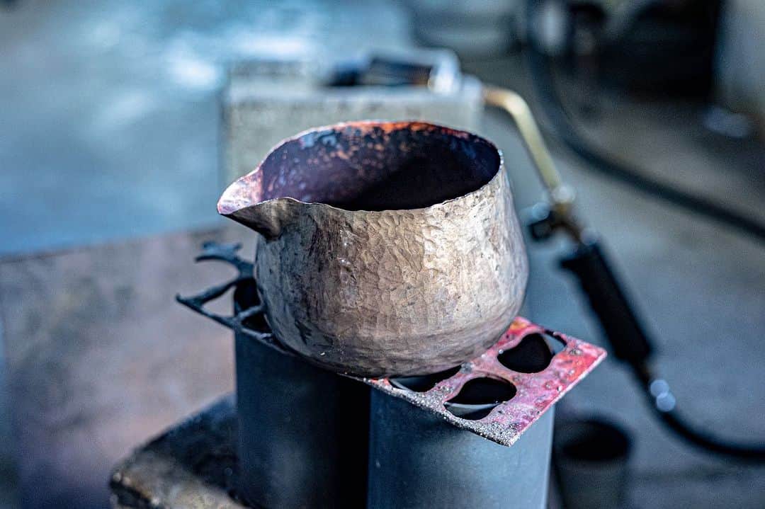近藤岳登さんのインスタグラム写真 - (近藤岳登Instagram)「富貴堂  @fuukidou   2日目  カタチが決まったら銅の上に錫を纏わせます。綿を使い丁寧に丁寧に錫を広げていきます。 その際、昔からの技法で、錫を纏わせる面以外は、泥で錫が付着するのを防ぎます。泥はすぐ乾き、洗えばすぐに落ちるのでこの工程は昔から泥を使うそうです。先人の知恵は凄い。  そして錫を纏わせた後、焼いてしっかり錫を馴染ませ、さらに丁寧に磨きます。  一気に雰囲気が変わり、一気に抜群のオーラを放ち出します。どんどん命が吹き込まれていきます。  Special thanks  Photo by @moo_ochan」10月31日 15時34分 - gakuto_kondo