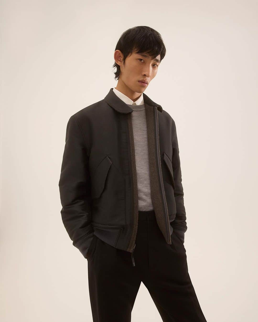 セオリーのインスタグラム：「Lucas Ossendrijver's Theory Project collection is all about elevating staple pieces. “Based on a slightly oversized aviator jacket, this bomber has a polished recycled poly side and can be reversed to a brushed wool body with quilted satin sleeves," he explains. "When you take a closer look at the binding along the closure and the leather finishing on the zipper tab, the workmanship really stands out.” #TheoryProject」