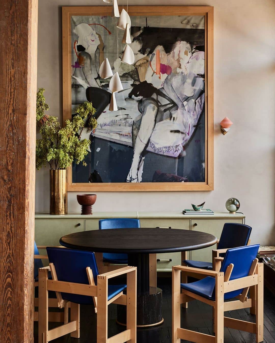 ELLE DECORのインスタグラム：「When Ciarán McGuigan (@orior_furniture) and his wife, Logann, purchased this Brooklyn apartment, which is located in a 1930s-era building, it was sectioned off into four or five small rooms. Naturally, that warrenlike floor plan didn’t last long. “We knew we wanted to have as much big, open space as possible,” adds McGuigan, who maximized the square footage with an open-plan dining room, living room, and kitchen, plus an adjoining skylit bedroom. A few toppled walls later, the space now functions as an open, airy entertainment hub. In the dining area of the loft, the painting is by @lou_ros_, the dining table is by @orior_furniture, and the chandelier is by @bocci.   Click the link in bio for the full tour, as shown exclusively on elledecor.com. Written by @helmadden. Photographed by @nicole_franzen.」