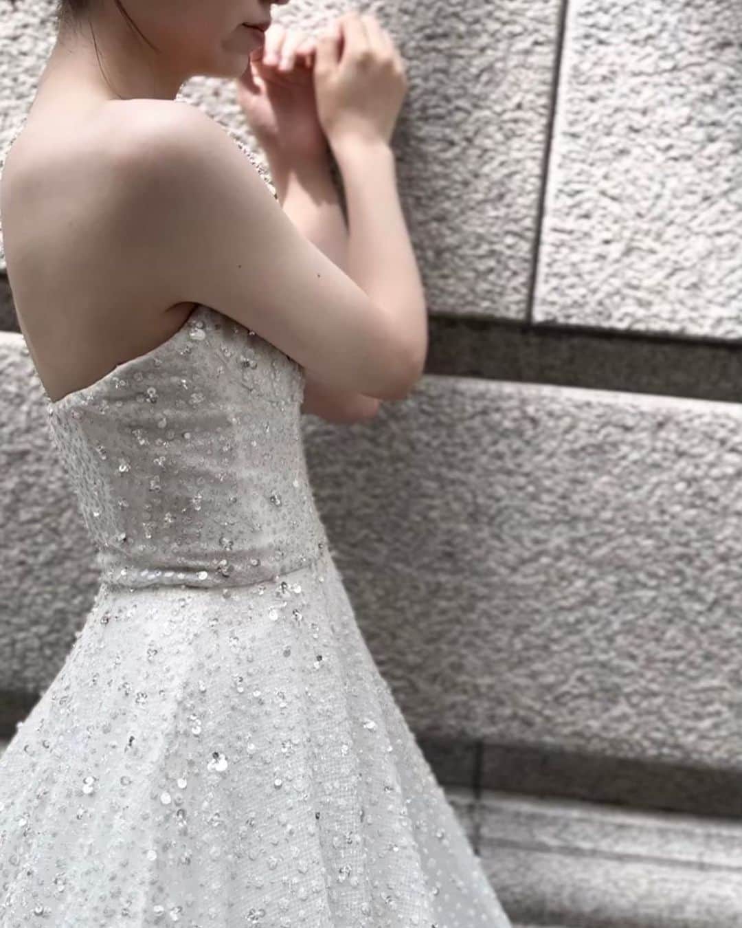 のインスタグラム：「***  グリッタードレスの魅力は「細部で決まる」  特別な日にキラキラと輝くドレスを纏う、 結婚式を控えた花嫁様なら一度は頭に浮かぶ 選択肢のひとつ。  そのニュークラシックスタイルの完成度を 高めるべく、形や組合せ方にフォーカスしたデザイン。  @nicolefeliciacouture / BL287  粒の大きさが異なるホワイトのラメが全体に広がり、 その上に適度に配置されたスパンコールが 品のある輝きへと昇華させている。  並べ方、素材の組合せ方にこだわりを感じる1着。  まるでシャンパンの気泡をイメージさせ 結婚をお祝いしているかのよう🥂✨  #mirrormirror #ミラーミラー」