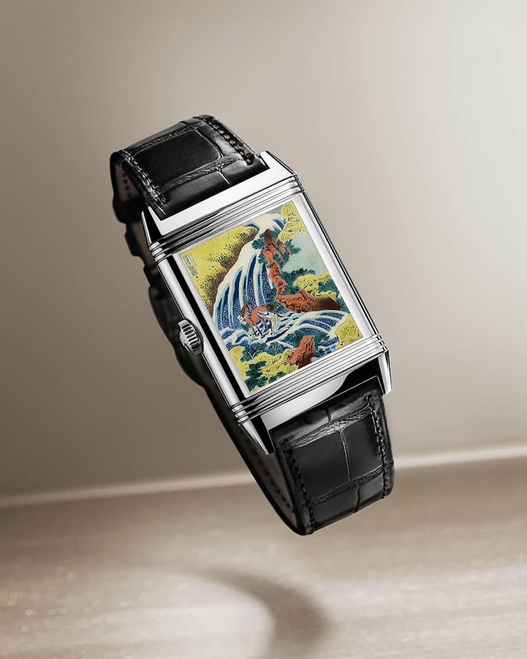 ジャガールクルトのインスタグラム：「A watchmaking homage to Hokusai. #Reverso _ Reverso Tribute Enamel Hokusai Designed, made and assembled in our Manufacture  _ Paying homage to Japanese artist Katsushika Hokusai, Jaeger-LeCoultre introduces the Reverso Tribute Enamel Hokusai decorated with his famous ‘Waterfalls’ series. Depicting a colourful waterfall on its verso, its recto reveals a dial entirely guilloché and enameled. A single watch uniting two works of art. _ #JaegerLeCoultre #Reverso」