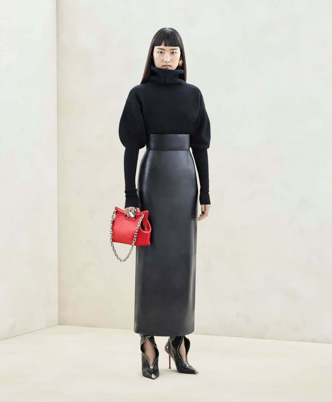 アレキサンダー・マックイーンのインスタグラム：「A funnel neck knit jumper and a bustier pencil skirt in black, worn with the red #McQueenPeak bag and Slash Biker boots.⁣ ⁣ Discover the #McQueenAW23 collection via the link in bio.⁣ ⁣ Photographed by @Jet.Swan」