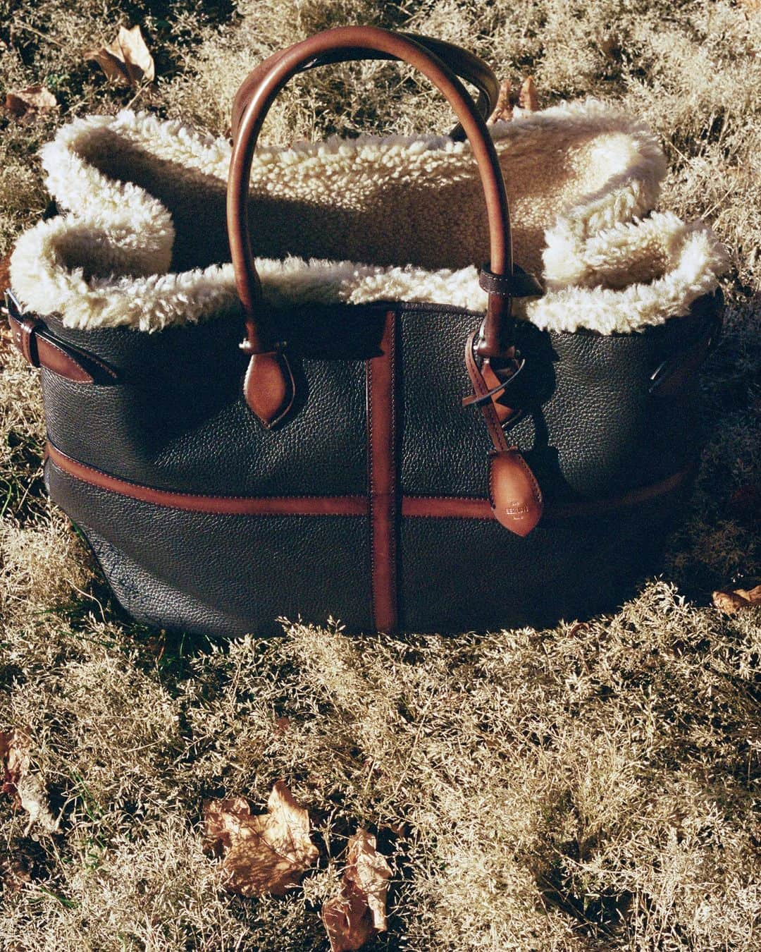 ベルルッティのインスタグラム：「- THE BAG: TOUJOURS XL BY #BERLUTI -   Spacious, functional and Winter-ready, the new Toujours XL tote blends an outdoors-inspired aesthetic with timeless details taken from the Jour line. Made of shearling-lined grained leather and Venezia strips, it is both resistant and graceful.   Now available online and in-store.  Photography by @deo_suveera   #BERLUTIWINTER2023」