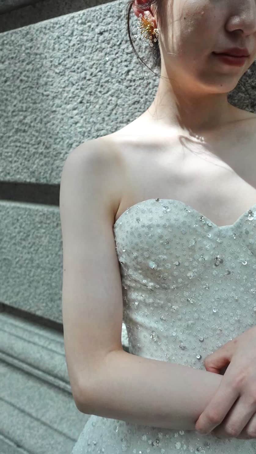 のインスタグラム：「***  グリッタードレスの魅力は「細部で決まる」  特別な日にキラキラと輝くドレスを纏う、 結婚式を控えた花嫁様なら一度は頭に浮かぶ 選択肢のひとつ。  そのニュークラシックスタイルの完成度を 高めるべく、 形や組合せ方にフォーカスしたデザイン。  @nicolefeliciacouture / BL287  粒の大きさが異なるホワイトのラメが全体に広がり、 その上に適度に配置されたスパンコールが 品のある輝きへと昇華させている。  並べ方、素材の組合せ方にこだわりを感じる1着。  まるでシャンパンの気泡をイメージさせ 結婚をお祝いしているかのよう🥂✨  #mirrormirror#ミラーミラー」