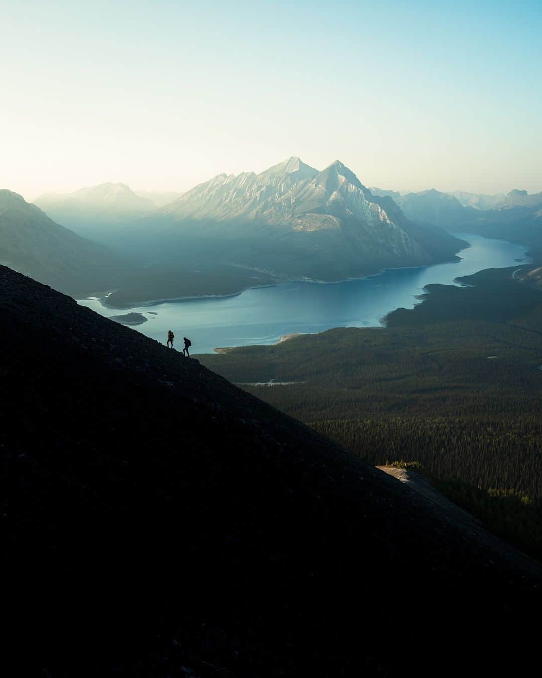 Explore Canadaさんのインスタグラム写真 - (Explore CanadaInstagram)「Introducing the Creators Network! We’ve brought together creatives from across the country to showcase what we love most about where we live.   Meet the first five creators!  📷 Photo 1-2: Ken @kenny_hagen, British Columbia 📷 Photo 3-4: Kimberley @westcoastlife, British Columbia 📷 Photo 5-6: Dave @davey_gravy, Alberta 📷 Photo 7-8: Kaila @kailawalton, Alberta 📷 Photo 9-10: Herry @herry.with.an.e, Saskatchewan  #ExploreCanadaCreator #ExploreCanada  Image description:  Photo 1) Person in a bright yellow jacket smiles at the camera. In the distance, there are green and yellow trees to one side and a snowy mountain to the other. Photo 2) A wide shot of two people climbing a mountain. In the background, grey mountains and green trees surround a blue water. Photo 3) Person in black jacket looks off to the side. In the back, light shines from above, illuminating trees and logs.  Photo 4) Two whales peek out of deep blue water. In the background, a small cabin and ramp to the water is surrounded by green trees. Photo 5) Person standing in front of a black and white backdrop smiles with arms crossed. Photo 6) Wide shot of a brown mountain range topped with green grass. Person walks along a path in the distance. Photo 7) Person stands on a beach in a red jacket. In the distance, there’s a body of water, a tree and snow capped mountains. Photo 8) A log cabin is surrounded by green trees. The sky is covered with purple, yellow and pink clouds. Photo 9) Person in a yellow jacket stands on a flat rock surrounded by water. Mountains sparsely covered with snow, lined with yellow and green trees are seen in the distance. Photo 10) A brown field and star-filled sky fill the frame. A big barn and two smaller barns along with two trees are in the distance.」11月2日 1時30分 - explorecanada