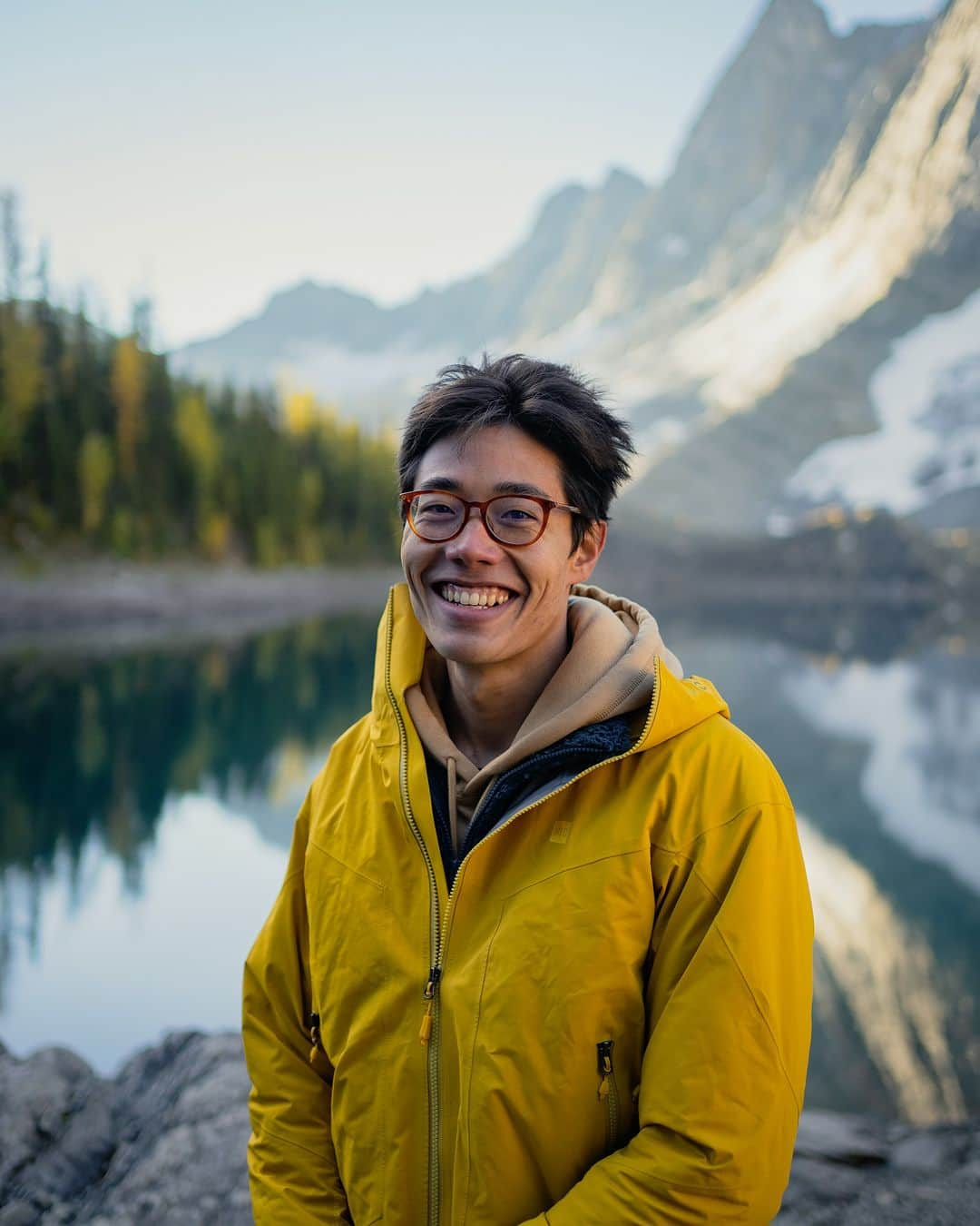 Explore Canadaのインスタグラム：「Introducing the Creators Network! We’ve brought together creatives from across the country to showcase what we love most about where we live.   Meet the first five creators!  📷 Photo 1-2: Ken @kenny_hagen, British Columbia 📷 Photo 3-4: Kimberley @westcoastlife, British Columbia 📷 Photo 5-6: Dave @davey_gravy, Alberta 📷 Photo 7-8: Kaila @kailawalton, Alberta 📷 Photo 9-10: Herry @herry.with.an.e, Saskatchewan  #ExploreCanadaCreator #ExploreCanada  Image description:  Photo 1) Person in a bright yellow jacket smiles at the camera. In the distance, there are green and yellow trees to one side and a snowy mountain to the other. Photo 2) A wide shot of two people climbing a mountain. In the background, grey mountains and green trees surround a blue water. Photo 3) Person in black jacket looks off to the side. In the back, light shines from above, illuminating trees and logs.  Photo 4) Two whales peek out of deep blue water. In the background, a small cabin and ramp to the water is surrounded by green trees. Photo 5) Person standing in front of a black and white backdrop smiles with arms crossed. Photo 6) Wide shot of a brown mountain range topped with green grass. Person walks along a path in the distance. Photo 7) Person stands on a beach in a red jacket. In the distance, there’s a body of water, a tree and snow capped mountains. Photo 8) A log cabin is surrounded by green trees. The sky is covered with purple, yellow and pink clouds. Photo 9) Person in a yellow jacket stands on a flat rock surrounded by water. Mountains sparsely covered with snow, lined with yellow and green trees are seen in the distance. Photo 10) A brown field and star-filled sky fill the frame. A big barn and two smaller barns along with two trees are in the distance.」