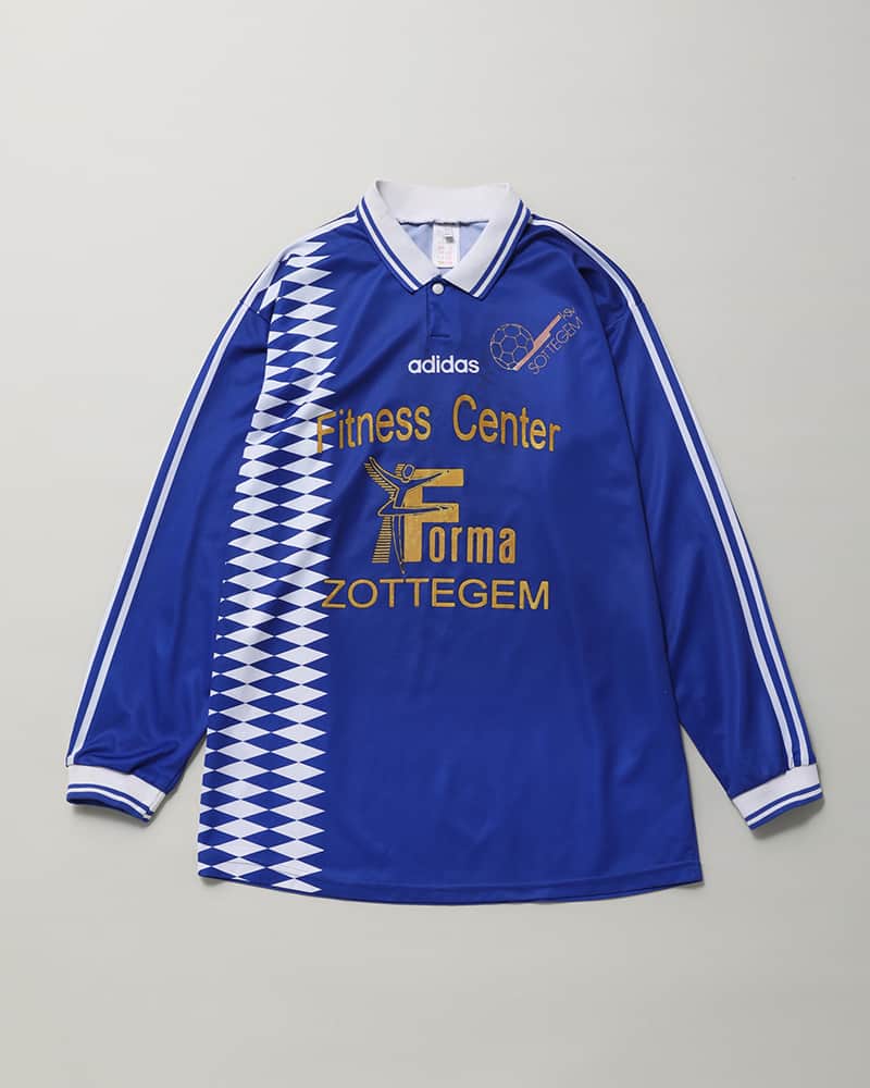 UOMOさんのインスタグラム写真 - (UOMOInstagram)「ユニフォームを街で着る Weekend Shulle -自分勝手な週末と服-  ユニフォームをファッションに取り入れる火つけ役となったサッカーウェアは、種類も豊富。デザインだけで選ぶのももちろん大いにアリだ。濃いブルーが鮮やかな古着の一枚は、’90年代前半にKSV Sottegemというベルギーの小規模なサッカーチームで着られていたもの。どうせなら大胆なハズシとして、スーツスタイルに合わせるくらい振り切ってみたい。  サッカーシャツ￥6,600／BENE　スーツ￥237,600／カルーゾ×ザ クラシック×ランド オブ トゥモロー（ランド オブ トゥモロー 丸の内店）　シューズ￥25,300／クラークスオリジナルズ（ビーミング ライフストア by ビームス ららぽーとTOKYO-BAY店）　バッグ￥63,800／ブレディ（ビショップ）  #ユニフォーム #BENE　#カルーゾ #ザクラシック  #ランドオブトゥモロー #クラークスオリジナルズ #ブレディ #uomo #uomo_magazine #webuomo」11月2日 12時00分 - uomo_magazine