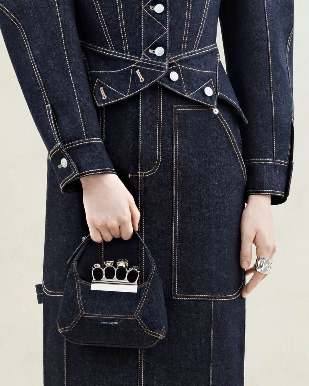 アレキサンダー・マックイーンのインスタグラム：「The Mini Jewelled #McQueenHobo bag and the upside-down jacket paired with the pencil skirt in indigo denim with tobacco stitching. ⁣ ⁣ Discover the #McQueenAW23 collection via the link in bio. ⁣ ⁣ Photographed by @Jet.Swan」