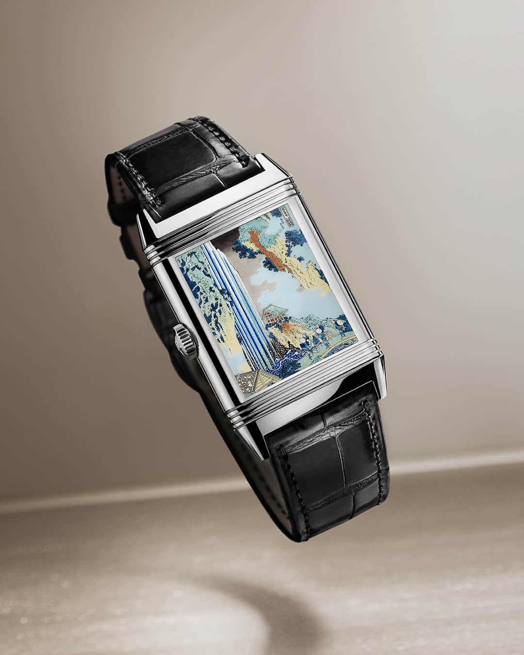 ジャガールクルトのインスタグラム：「A single watch uniting two works of art. #Reverso _ Reverso Tribute Enamel Hokusai Designed, made and assembled in our Manufacture  _ Reflection of Hokusai’s deep attachment to nature, the new Reverso Tribute Enamel Hokusai displays a meticulous reproduction of the painting ‘The Waterfall at Ono’ on its verso. On its recto, the timepiece features a dial entirely guilloché by hand with a classical barleycorn pattern, requiring three to four hours of painstakingly accurate work.  _ #JaegerLeCoultre #Reverso」
