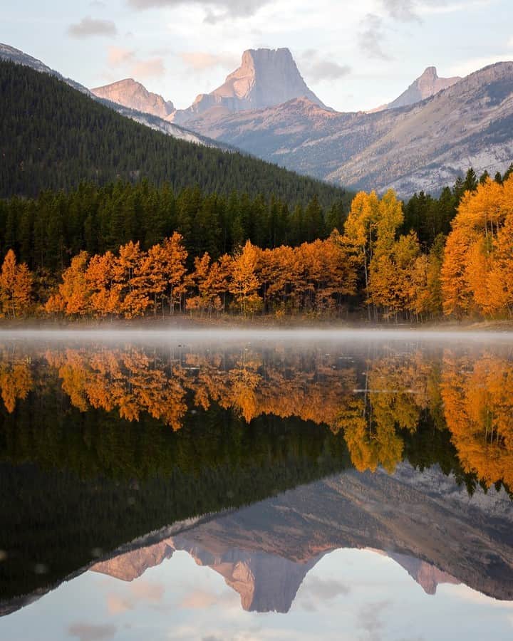 National Geographic Travelのインスタグラム：「Photo by Kahli Hindmarsh @kahliaprilphoto | On a perfectly still fall morning in the Canadian Rockies, the first light of day touches the mountains. The fall colors don't last long in the Rockies, but they sure are spectacular while they’re here!   Follow me @kahliaprilphoto for more breathtaking landscapes from around the world.」