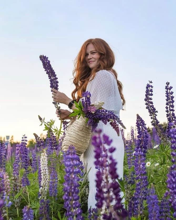 Explore Canadaのインスタグラム：「Say hello to the next five creators in our Creators Network!  In case you missed it, we’ve brought together creatives from across the country to showcase what we love most about where we live.   📷 Photo 1-2: Stephanie @theredheadroamer, Prince Edward Island 📷 Photo 3-4: April @peggrammer, Manitoba  📷 Photo 5-6: Sanjana @wanderesswithastory, Ontario 📷 Photo 7-8:  Julia @juliaxweber, Ontario 📷 Photo 9-10: Jeanne @jeannemap, Quebec  #ExploreCanada #ExploreCanadaCreator  Image description:  Photo 1) Person wearing a white long dress stands in the middle of a purple and green flower field. Photo 2) Aerial view of red cliff and green grass on top. Tide rolls in on a red sandy beach. Photo 3) Person with arms crossed, smiling and looking off to the side in front of a white background. Photo 4) People staring into the evening sky as fireworks light up. They’re standing in front of two geometric buildings and a sign that says “Winnipeg”. Photo 5) Person in a pink dress stands in front of a blurred background of red and green trees. Photo 6) Person standing in front of a waterfall surrounded by yellow, green and orange trees. Photo 7) Person walking down path framed with green, yellow and orange trees. Tall building and body of water seen in the distance. Photo 8) Purple, pink and yellow clouds paint the sky, and reflect off a vast body of water. To one side, there is a forest and to the other are trees and rocks. Photo 9) Person with hands in pockets looking off to the side. Bare trees and rocks are in the background. Photo 10) Three children playing on a rocky beach. Mountains are in the distance. Pink and orange sunset fills the sky.」