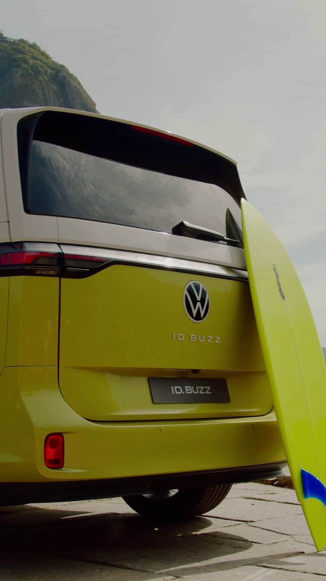 Volkswagen do Brasilのインスタグラム：「Novidade para quem quer um VW elétrico: O ID. Buzz, a nova Kombi, já está disponível pelo serviço de aluguel Sign&Drive. Transforme sua vida com inovação e sustentabilidade. #VWBrasil #IDBuzz  #VWParaTodos Vídeo de um ID. Buzz amarelo e branco passando pelas ruas do Rio de Janeiro em um dia de sol. Vemos o Cristo Redentor ao fundo e o texto: “Novo VW ID. Buzz”. Corta para uma prancha de surfe amarela apoiada na parte traseira do carro, uma mão coloca o carregador no carro e o texto: “100% elétrico”. As duas portas laterais se abrem e vemos o Pão de Açúcar ao fundo e o texto: “Já disponível no Sign&Drive”. Finaliza com o veículo indo em direção ao pôr do sol no Pão de Açúcar.」