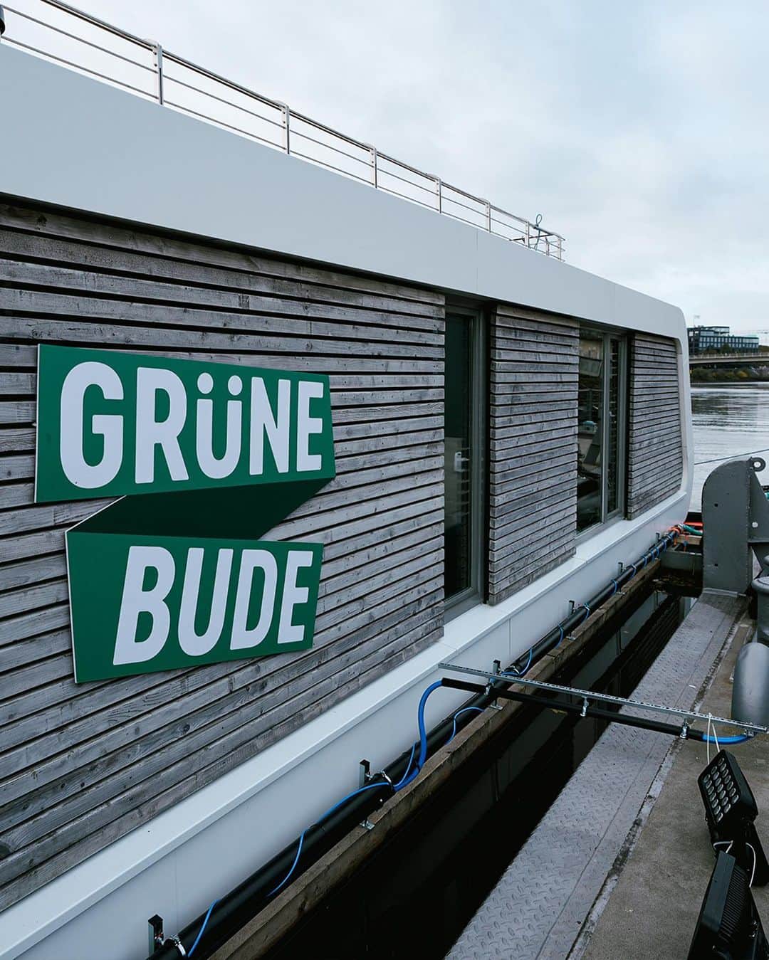 ヴェルダー・ブレーメンのインスタグラム：「𝗠𝗼𝗶𝗻 Grüne Bude! 👋  Einst war es das erste Vereinsheim des SV Werder – nun ist es ein Veranstaltungsort und eine Begegnungsstätte für alle Werderaner:innen. 💚  Auf der anderen Weser-Seite, einen Katzensprung hinüber auf dem Stadtwerder, stand sie: die originale "Grüne Bude". Doch anders als noch vor 125 Jahren liegt die neue "Grüne Bude" direkt auf der Weser. Nun ist es ein Mix aus Café, Veranstaltungsort, ein Ort der Werder-Historie, eine Werder-Workshop-Werkstatt und ein Mini-Fan-Shop - kurz gesagt: Ein Ort für 𝗘𝗨𝗖𝗛!  Weitere Infos findet ihr in unserer Story!  ____ #werder #bremen #svw #llgw #gruenebude #unseregruenebude」
