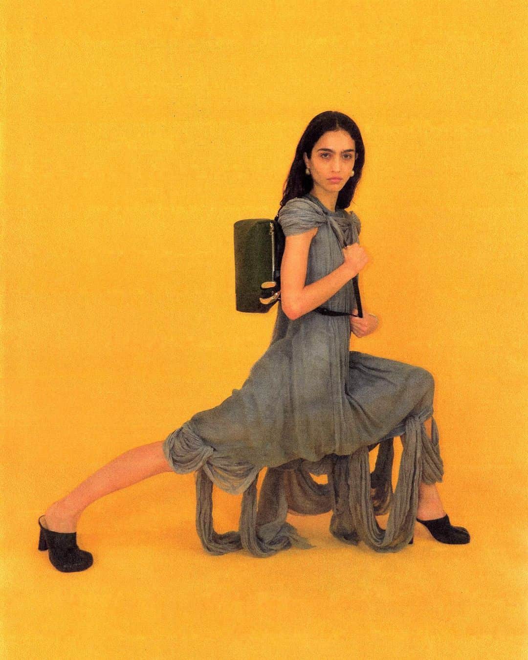 JWアンダーソンのインスタグラム：「WINTER 2023  Sara wears Sleeveless Midi Dress, The Corner Bag and The Paw Mules  Credits: Creative direction @Jonathan.Anderson Photography@JoeCruzStudio  Set Design @RoryWMullen  Hair @TommyStayton  Make up @AnneSophieCosta  #jwanderson」