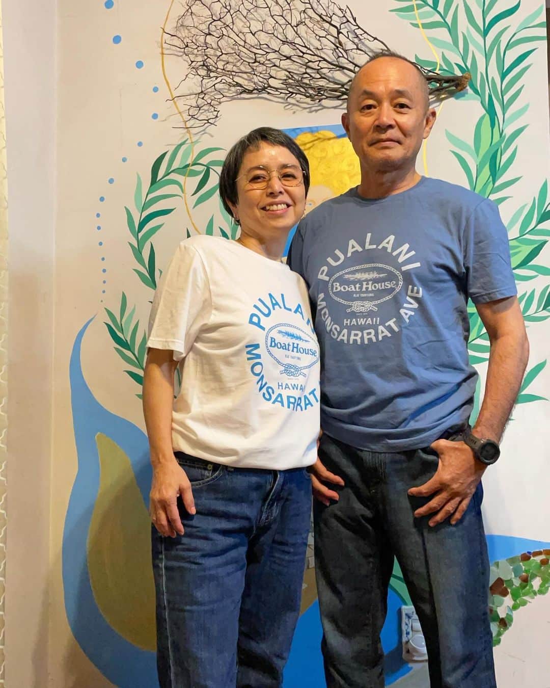 Pualani Hawaii Beachwearのインスタグラム：「沖縄のプアラニマーメイドめぐみさん🧜‍♀️  アーティストでもあるめぐみさん。 背景に見えるのは、彼女が手がけた ウォールアートです🌺  沖縄各地で展⺬会も開かれているそうですよ🥰  お二人とも、とってもお似合いです〜🫶🏼  着用サイズは以下になります⏬  ボートハウスTシャツ 旦那様Mサイズ 奥様Sサイズ  MAHALO !!  ■販売価格　42ドル ■サイズ　S・M・L・XL（男女兼用） ■販売店舗　プアラニ・ハワイ・ビーチウェア（モンサラット店） ■販売サイト　pualanibeachwear.com（日本への発送可能）  送料は通常通りお買い上げ金額が300ドルまで一律35ドルとさせていただくことになりました。 Tシャツが一枚のみであれば20ドルでお送り可能ですが大変割高です。割高でも構わないから一枚だけの発送をご希望という方はご購入前にこちらまでご連絡ください。contact@pualanibeachwear.com  ※製品情報・コラボ企画に関する詳細は、@pualani_monsarrat InstagramプロフィールURLにございます。  #ハワイ限定 #hawaii #ハワイ #ハワイ旅行 #ハワイ土産 #ハワイ好きな人と繋がりたい #ハワイ購入品 #ハワイ好き #ハワイ暮らし #ハワイ情報 #ハワイお土産 #aloha #ハワイ旅 #ハワイ限定品 #ハワイショッピング#モンサラット#プアラニハワイ#ボートハウス#キャプテンサンタ#モンサラットアベニュー#プアラニハワイビーチウェア」