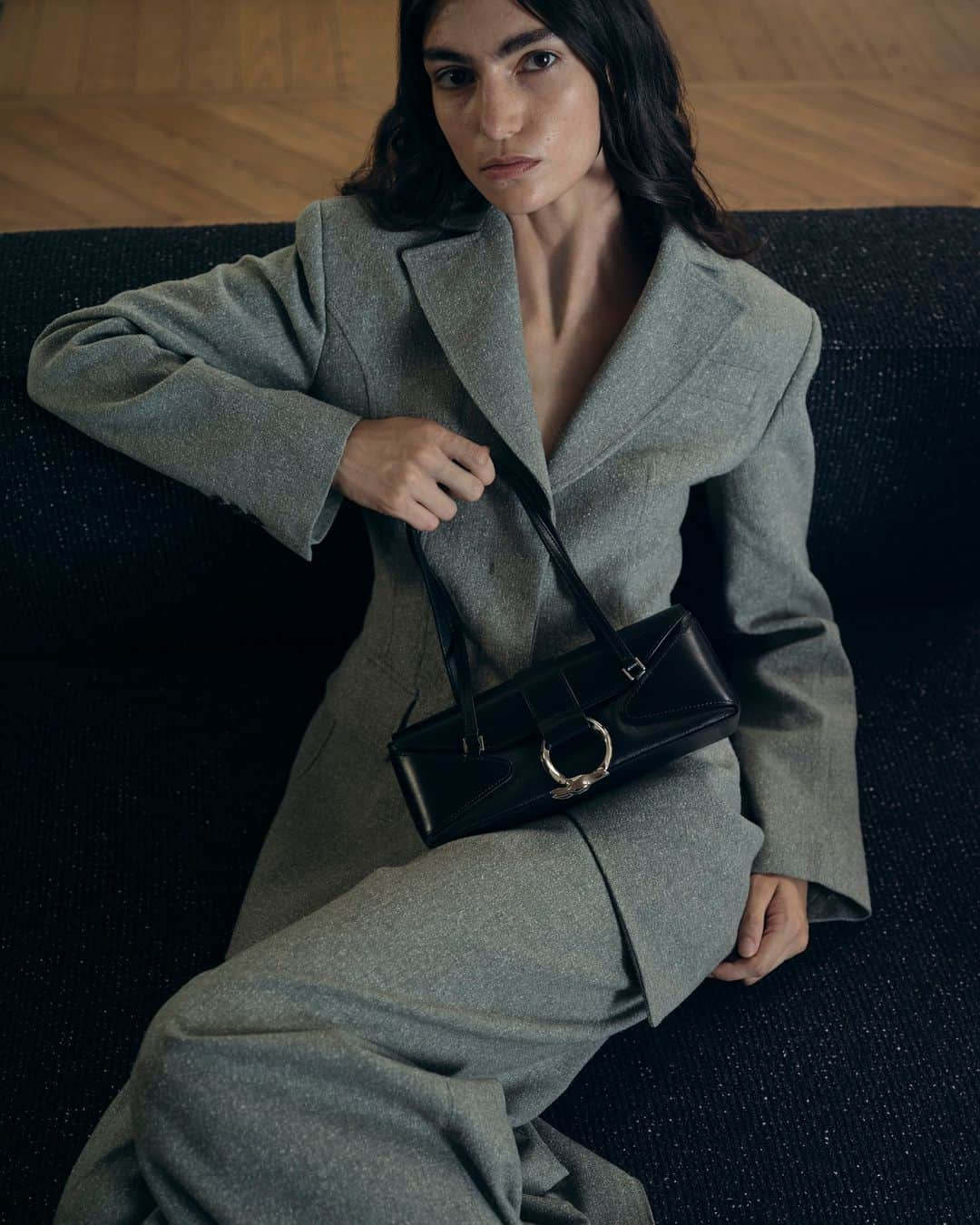 トラサルディのインスタグラム：「The #TrussardiFW23 collection proposes a contemporary take on tailoring, with classic women's pantsuits updated into a modern, semi-exaggerated hourglass shape. The look is captured here with the Meroe baguette, a sleek accessory featuring a geometric combination of leather and coated canvas.  Photographed by @ferry_mohr  Shot on location at @onhousemilano」