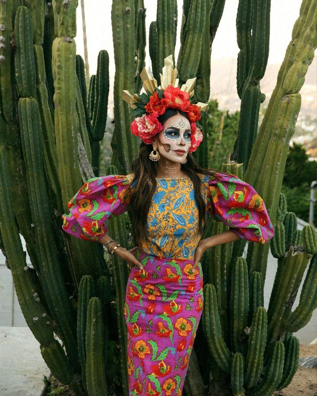 ジュリー・サリニャーナのインスタグラム：「Yesterday we celebrated Día de Muertos and it’s one of my favorite Mexican traditions of the year! Day of the Dead for those of you who don’t know is a holiday we celebrate in Mexican culture, that pays homage & remembrance to our ancestors + family + friends who have passed away. It’s a joyful celebration of life rather than somber one. I love honoring my roots and celebrating my loved ones who are no longer with us.   This year is extra special because I get to share my beautiful Mexican culture and tradition with my Bebe Matisse! I’m looking forward to teaching him more about it as he gets older and celebrating together! 🫶🏽  Another special part of DDLM is how my sisters and I made this a yearly sister tradition where the three of us dress up together. I love we get to bond while celebrating our roots!   This years look is a modern Mexican chic look with bold colors and pretty floral on floral prints! What do you guys think? 🌸☠️🫶🏽  My DDLM makeup and floral crown is by my insanely talented big sis @lilylive213 @lilylacatrina . She’s the Queen of Catrina’s! Always inspired by her! ☠️🫶🏽🌸 ILYSM sis!!!!  #DiaDeMuertos #DiaDeLosMuertos #DayOfTheDead #Catrina #ddlm」