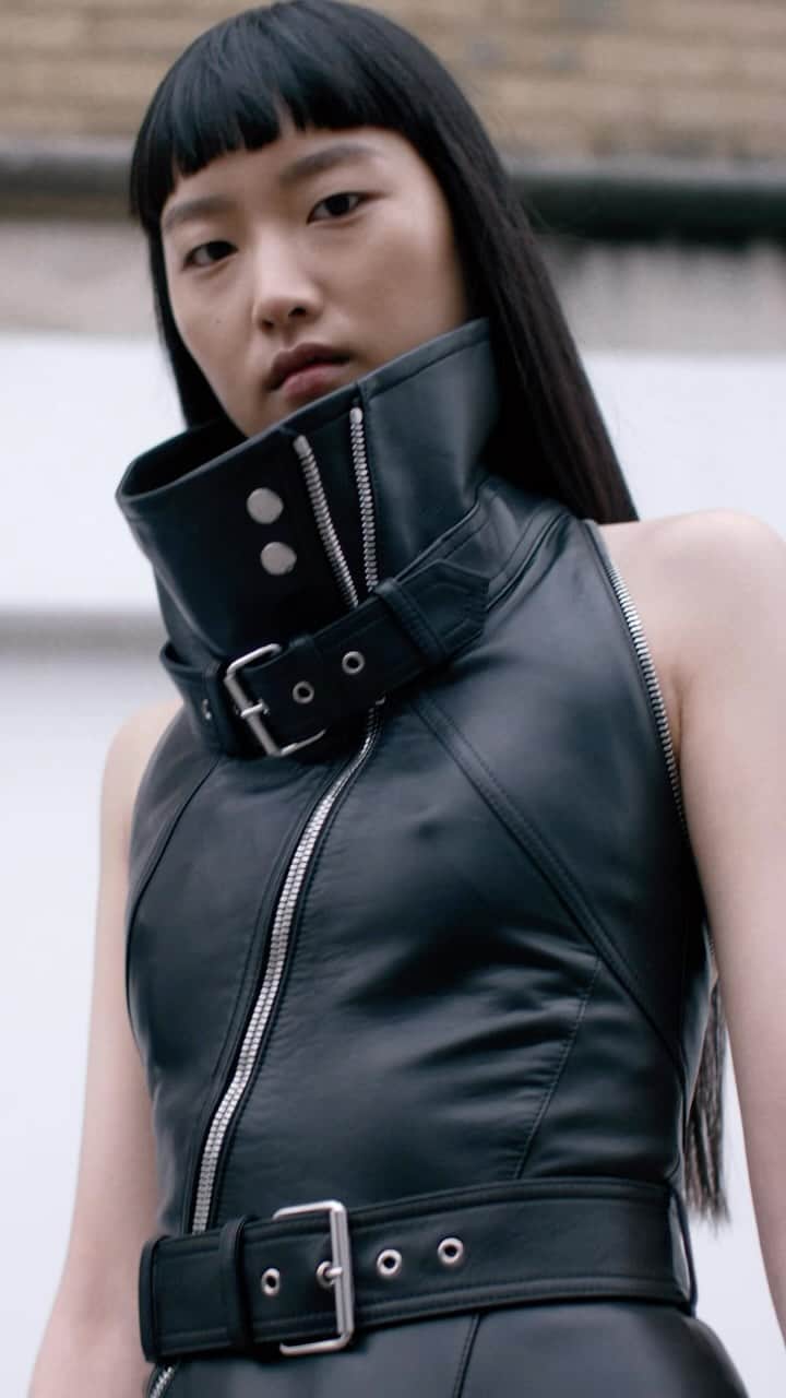 アレキサンダー・マックイーンのインスタグラム：「A black twisted funnel neck biker dress worn with Slash Biker boots.  Discover the #McQueenAW23 collection via the link in bio.   Video by @EbbaHult Track: Neurons by @roblewiscomposer Music Director: John Gosling」