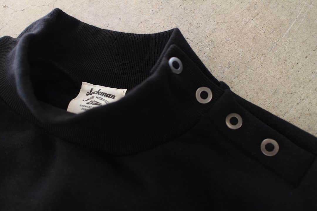 のインスタグラム：「▽ FW23 STRETCH SWEAT MIDNECK JM7377 95%COTTON 5%POLYURETHANE ￥24,200 Color:07  表糸と中糸に ポリウレタンをカバーリングした 綿糸を使用して ストレッチ性をもたせた 裏起毛スウエットミッドネックです  希少編み機のアズマ編み機を使用して ポリウレタンの縮む力を利用し あたかも度詰めしたかのような 特徴的な凝縮感を出しました  1920‐40年代に登場した 無骨なシルエットの Baseball防寒用練習着を参考に 1枚で着用できるように ゆったりした設計でデザインしました  ボリュームのある袖は 三角パーツ切り替えで生地の無駄を省き 太番リングスナップボタンで 肩部分のサイドが開閉可能ですので 着脱が容易です  寒い日でもアウターに頼らず 着用できる冬のスウエットです  Our raised back Sweat Midneck is made with cotton yarn coated with polyurethane on the front and middle yarn, giving it stretchability. Using a rare Azuma knitting machine, we utilized the shrinkage power of polyurethane to create a distinct condensed feel, giving it the impression of being densely packed. The design has a relaxed fit inspired by the rugged silhouette of baseball cold-weather training wear that emerged in the 1920s to 1940s, so it can be worn alone. The voluminous sleeves were designed with triangular parts to minimize fabric waste, and the shoulder side can be opened and closed with a thick ring snap button, making it easy to put on and take off. You can wear this winter sweatshirt without relying on outerwear even on cold days.」