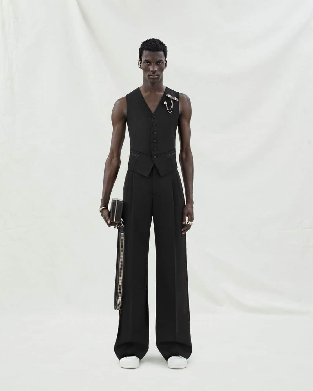 アレキサンダー・マックイーンのインスタグラム：「A black tailored waistcoat with a twisted seam and two-pleat wide-legged tailored trousers with satin detail. Finished with silver metal dragonfly earcuffs and brooches.⁣ ⁣ Discover the #McQueenMenPreSS24 collection via the link in bio.⁣ ⁣ Photographed by @Jet.Swan ⁣⁣ Video by @EbbaHult⁣ Track: Indigo by Hit By A Rock⁣ Music Director: John Gosling」