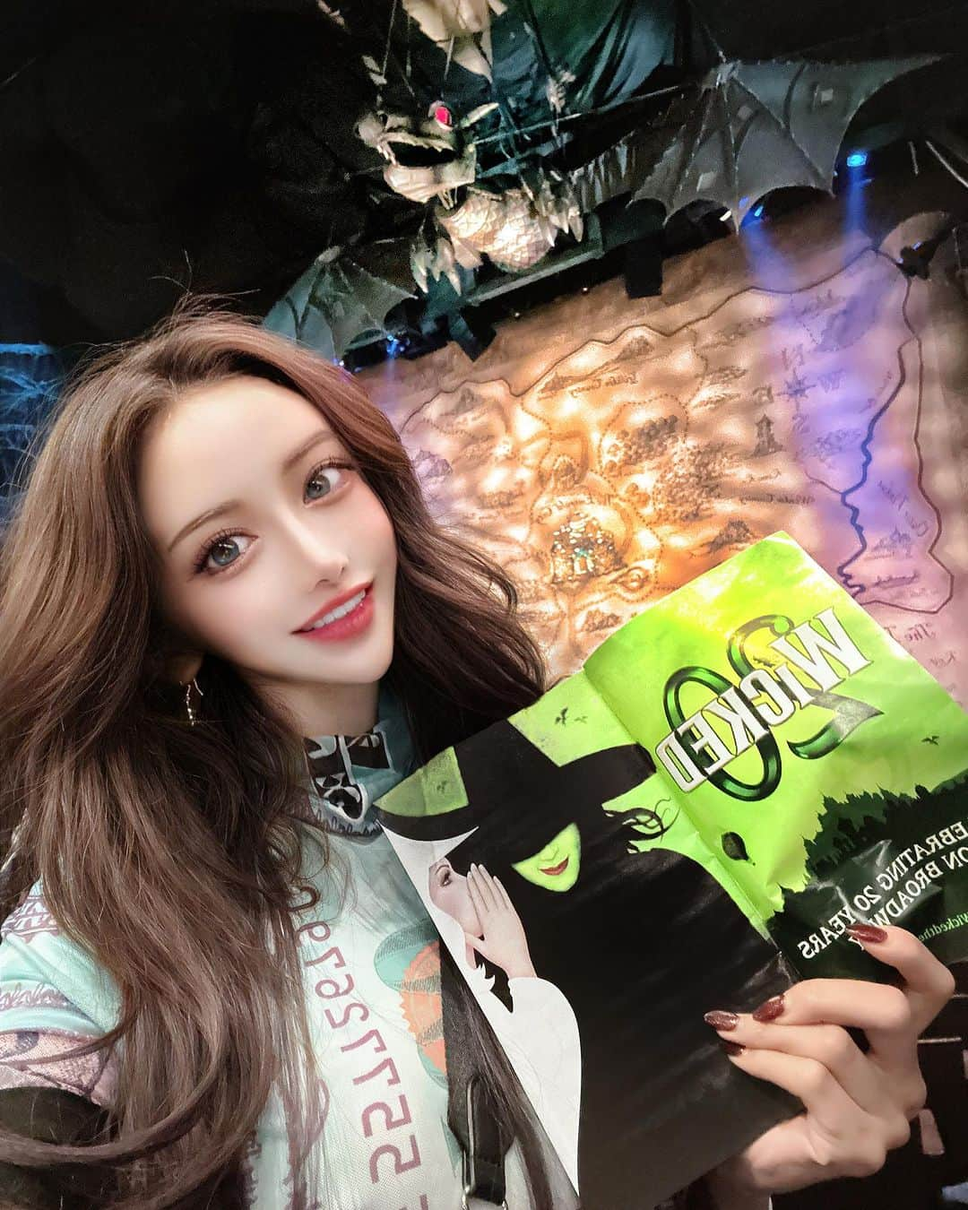 MARIのインスタグラム：「🎭💚✨𝐖𝐢𝐜𝐤𝐞𝐝✨💚🪄🎪🎟️  ウィキッドは、ブロードウェイで ずっとずっと愛されてきたミュージカル✨  オズと魔法使いのその前のお話、、 西の魔女がどうして悪い魔女になってしまったのか🐈‍⬛  2人の魔女と美しいGreenに包まれる謎💚✨🪄  私はこのミュージカルを 本当ーーーに、愛してやまないの🥲💚 高校生の時ウィキッドを初めて聞いて、  歌声に感動が止まらなくて何度も泣いた🥲✨  このウィキッドの音楽が大好きで 毎日聞いて歌って踊って、家でミュージカルしてた笑笑  この歌に感動して、、、、 その歌声はイディナメンゼル✨🩵 アナと雪の女王のエルサです😭✨  ウィキッドの大人気曲、Defying Gravity ✨自由を求めて  この曲が本当ーーーに大好きで😭✨  いつか絶対にブロードウェイでミュージカルを 見たい！！って心に決めていて、、  やっとやっと、大人になって観ることができました😭💚  きっとこの会場の中で1番のウィキッド熱狂的ファン🥲✌️🥲✨✨  会場に着くなりGreenに包まれた空間に感動しつつ、 劇場に入ると、こうなっているんだ！！って🥹💚✨ たくさんの発見と期待とワクワク🥲🥲  本当やっぱり運命なのか、、一席ド真ん中、前席が ほんんんとひとつだけ空いてて、、そこ予約できたんだけど いや運命だなぁて思った😭✌️☜笑  席に座って幕を眺めるだけで、心臓発作おこりそうな くらい1人感動してる中、、ショーは始まり✨✨🥹  わたしがいままで音楽だけで聴いてたミュージカルは  美しい彩り✨と輝きに満ち溢れて✨、、 わたしの期待を遥かに超えて本当に素晴らしかった 驚きと圧倒の3時間、、何もかも輝いてて眩しかった🥲✨✨✨　  歌声が生で聴ける空間、もう本当に幸せすぎた😭 こんなに美しい場所があるんだって 改めて、感動した😭✨✨  ここにきて、本当に本当に、よかった😭✨ 心からそう思いました🥲✨✨  グッズはもう売店にある全てのものをGETしたよ🤣🤣✨笑笑　一生の思い出になった😭✨💚最高😭💚  #wicked #broadwaymusicals  #wickedbroadway  #newyork  #newyorkbroadway」