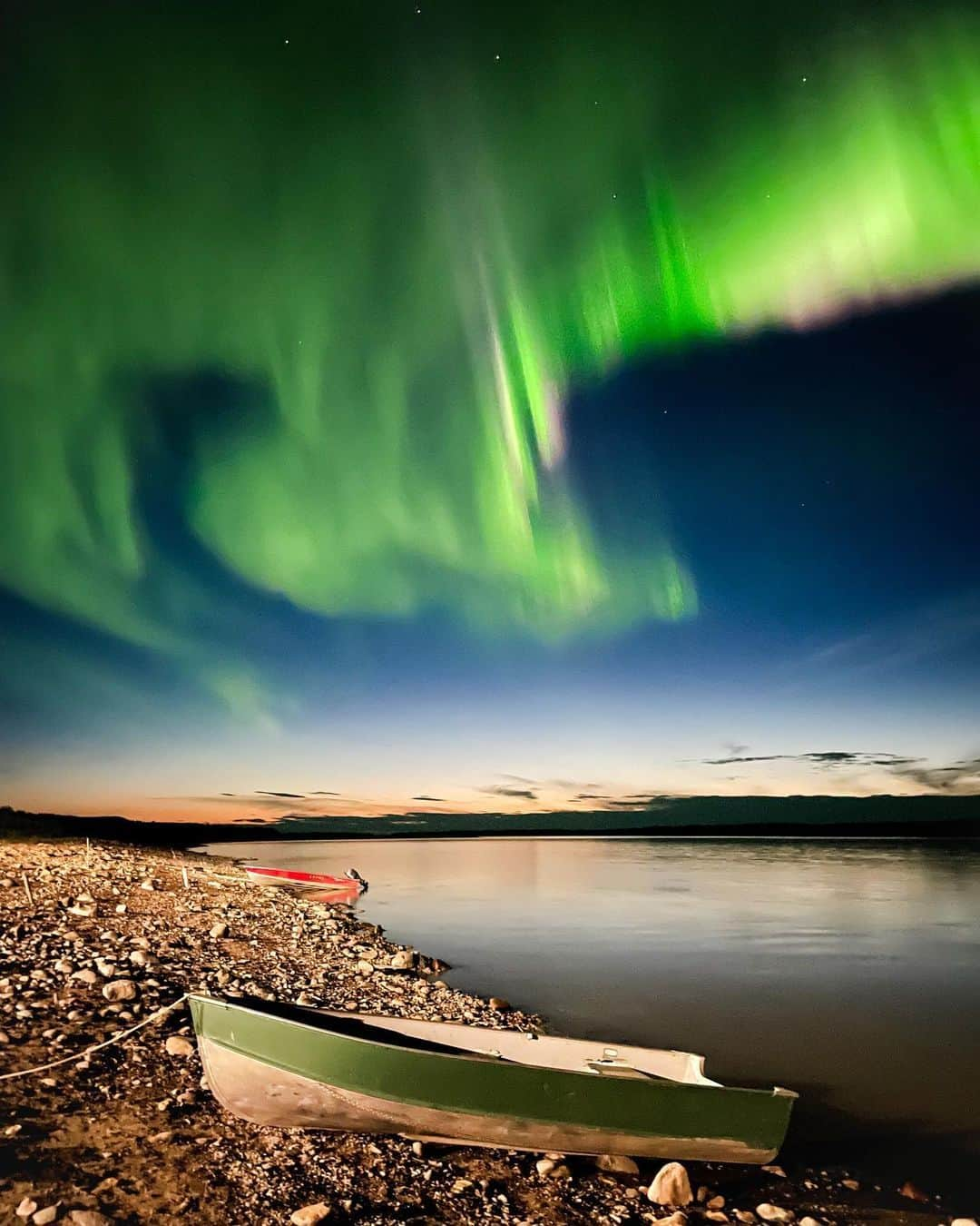 Explore Canadaさんのインスタグラム写真 - (Explore CanadaInstagram)「Introducing the final three creators in our Creators Network!  Check out our previous posts to learn more about our new Creators Network and the other creators.  📷 Photo 1-2: Tammy @tammyplarkin, Northwest Territories 📷 Photo 3-4: Jenny @jdubcaptures, Nunavut 📷 Photo 5-6: Danielle @danimarielister, The Yukon  #ExploreCanada #ExploreCanadaCreator  Image description:  Photo 1) Person in a cream, blue and brown sweatshirt stands in front of a blurred background of green and yellow trees. Photo 2) A green boat and a red boat are docked on a rocky beach. Flashes of bright green light illuminate a dark blue sky and reflect off a body of water. Photo 3) Person wearing a black parka is looking off into the distance with her hands in her pocket. Gray and blue clouds fill the sky. Photo 4) A tall red and brown rock formation surrounds a rocky beach. A boat is docked on the edge of the beach. Blue green water surrounds another rock formation that has two pillars. Blue and grey clouds paint the sky. Photo 5) Person in a red jacket smiles, snow covered trees and mountains are blurred in the distance. Photo 6) Wide shot of two mountain ranges covered in green trees and topped with snow. In between, there’s a turquoise body of water.」11月5日 1時33分 - explorecanada