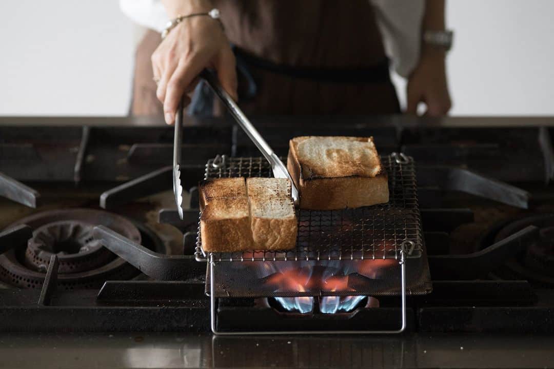 ヒラハルさんのインスタグラム写真 - (ヒラハルInstagram)「わざわざの定番ロングセラー、辻和金網の「足付き焼き網」。家庭用ガスコンロで手軽に網焼き料理ができる優れものです。  分厚く切ったわざわざのパンを置いて炙れば、 外はカリッ！中はふわっ。網焼きならではの焼き上がりです。  ▶️足付き焼き網｜辻和金網　¥4,840 https://wazawaza.shop-pro.jp/?pid=89736683  パンはもちろん今の季節ならナスやお魚、冬にはお餅を焼いたり、万能に使えて活躍の場も多いです。少々、ガスコンロは汚れてしまいますが、焼き鳥も香ばしくて美味しく焼けました。  直火はやっぱりすごい。目の細かい「焼網受」がガスの直火を和らげ熱をまんべんなく広げてくれるので、トースターで焼いたのは全くの別物のパンになります。一度試して欲しい一品です。  @wazawazapan 🤞お買い物はプロフィールリンクより 『わざわざオンラインストア https://waza2.com/』をタップ  ・・・・・・・・・・・・・・・ ▼わざわざオンラインストア https://waza2.com/  ▼わざわざのパン・お菓子 https://kinarino-mall.jp/brand-2482  ▼【限定クーポンが届くかも】メルマガ登録はこちら https://wazawaza.shop-pro.jp/secure/?mode=mailmaga&shop_id=PA01189522  #パンと日用品の店わざわざ #わざわざ #wazawaza #わざわざパン #焼き網 #足付き焼き網 #辻和金網」11月5日 19時00分 - wazawazapan