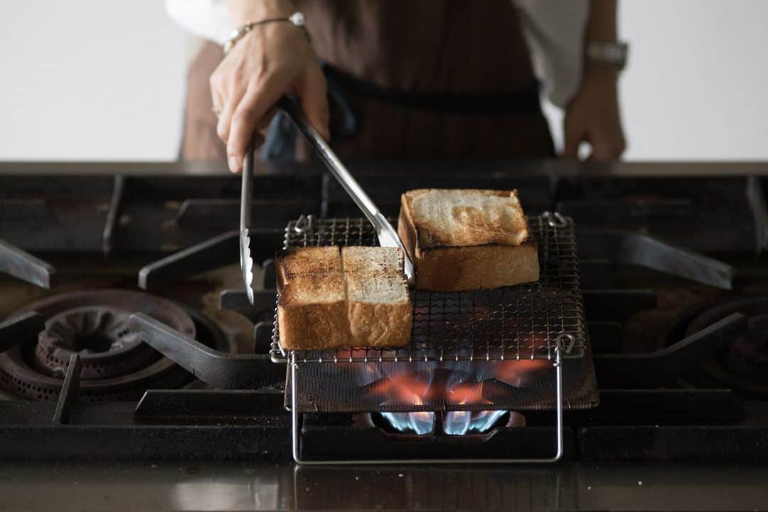 ヒラハルのインスタグラム：「わざわざの定番ロングセラー、辻和金網の「足付き焼き網」。家庭用ガスコンロで手軽に網焼き料理ができる優れものです。  分厚く切ったわざわざのパンを置いて炙れば、 外はカリッ！中はふわっ。網焼きならではの焼き上がりです。  ▶️足付き焼き網｜辻和金網　¥4,840 https://wazawaza.shop-pro.jp/?pid=89736683  パンはもちろん今の季節ならナスやお魚、冬にはお餅を焼いたり、万能に使えて活躍の場も多いです。少々、ガスコンロは汚れてしまいますが、焼き鳥も香ばしくて美味しく焼けました。  直火はやっぱりすごい。目の細かい「焼網受」がガスの直火を和らげ熱をまんべんなく広げてくれるので、トースターで焼いたのは全くの別物のパンになります。一度試して欲しい一品です。  @wazawazapan 🤞お買い物はプロフィールリンクより 『わざわざオンラインストア https://waza2.com/』をタップ  ・・・・・・・・・・・・・・・ ▼わざわざオンラインストア https://waza2.com/  ▼わざわざのパン・お菓子 https://kinarino-mall.jp/brand-2482  ▼【限定クーポンが届くかも】メルマガ登録はこちら https://wazawaza.shop-pro.jp/secure/?mode=mailmaga&shop_id=PA01189522  #パンと日用品の店わざわざ #わざわざ #wazawaza #わざわざパン #焼き網 #足付き焼き網 #辻和金網」