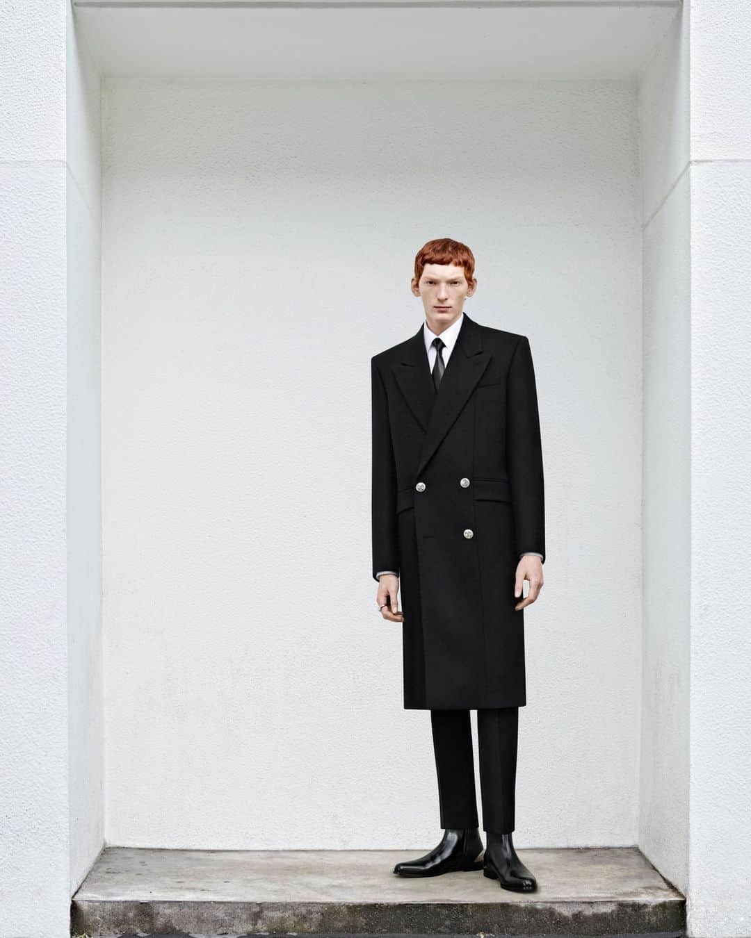 アレキサンダー・マックイーンのインスタグラム：「From #McQueenMenPreSS24, a black double-breasted tailored coat with silver metal seal buttons. Worn with cigarette trousers, a shirt in white cotton poplin and a black tie.⁣ ⁣ Discover the new collection via the link in bio.⁣⁣ ⁣⁣ Photographed by @Jet.Swan ⁣⁣ Video by @EbbaHult ⁣⁣ Track: Indigo by Hit By A Rock⁣⁣ Music Director: John Gosling」