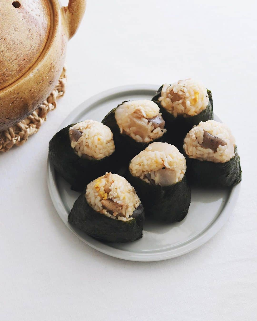 樋口正樹のインスタグラム：「oden onigiri 🍙  今朝はおでんごはんでおにぎり。 コレけっこうおいしいんですよ😋  お米１合半に大根、こんにゃく、 がんも、卵、つみれ、牛蒡巻き、 すこし煮詰まった濃いおでん汁、 土鍋で炊いて混ぜ混ぜにぎにぎ。 崩れやすいので焼き海苔は必須。  . #おでんごはん #おでんおにぎり #炊き込みご飯おにぎり #おにぎり #onigiri #onigiriaction」