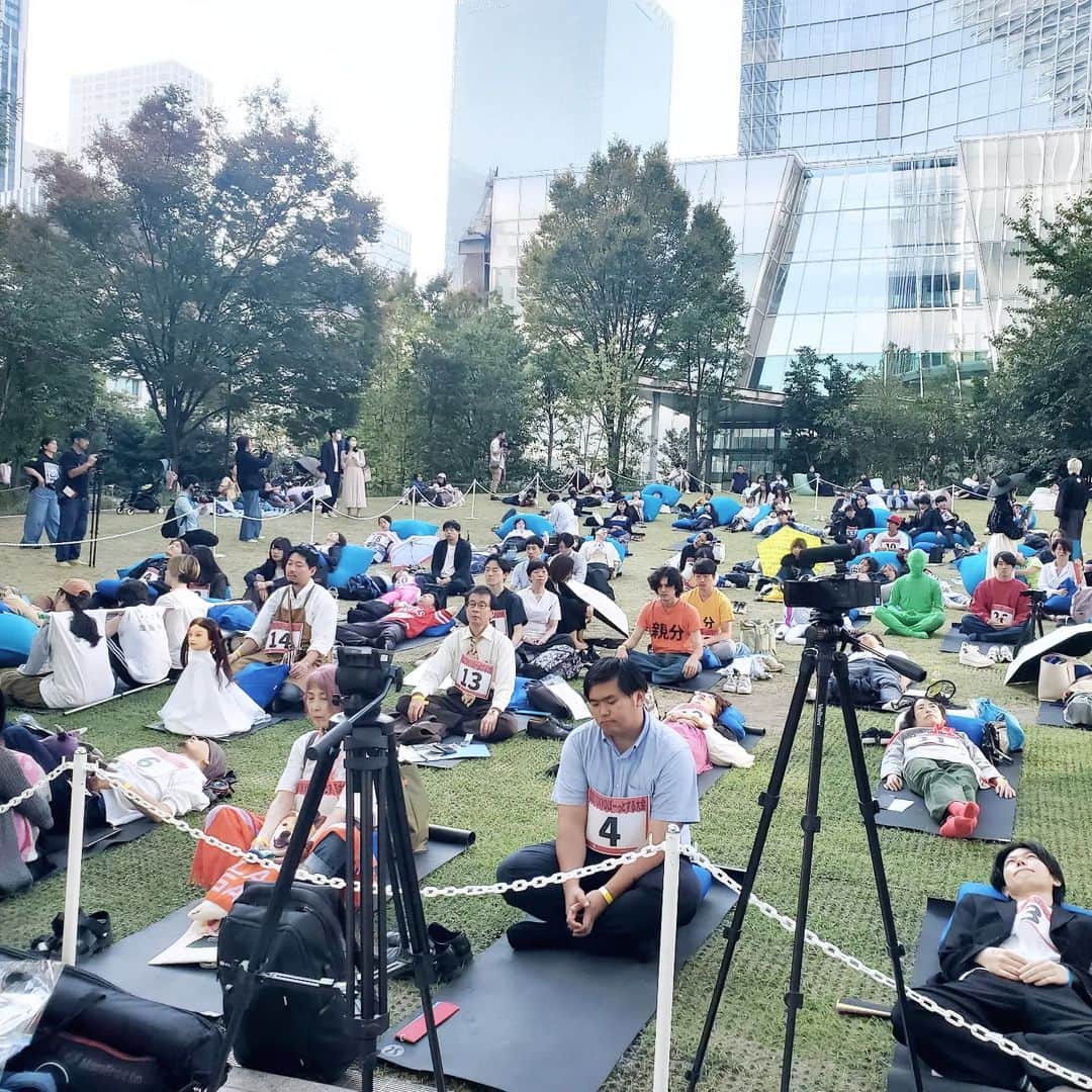 常世晶子さんのインスタグラム写真 - (常世晶子Instagram)「東京ぼーっとする大会の司会&実況をして来ましたので投稿を😊  2014年に韓国アーティスト、ウップスヤンさん(写真1枚目)によって企画考案された大会で、これまで世界6か国で開催。今回日本で初開催でした🎵  場所は虎ノ門ヒルズのオーバル広場にて、64組100名の方が参加。ぼーっと日本一が決まりました✨✨  すでに各テレビ局でNEWSとして取り上げられ、明日7日の朝は、日テレ早朝の「oha4!」でも体験レポート等入るのかと思いますが、100名がゼッケンをつけて様々な職業の方が…と言うと、とても馴染みのある現場🙄  今回は、緊張と弛緩の弛緩の方でしたので、私も場に合わせて緩やかに話せて楽しかったー🎤 風を感じながら気持ちを合わせるの大好き💓  次回開催も楽しみです！  後ろの写真は、お友達で運営のあこちゃん、プロデューサーの古井さん(実は大学生)、水溜まりボンドのカンタさん(参加者)と。  #ぼーっとする大会 #TOKYOぼーっとする大会 #日本初開催  #司会 #実況 #インタビュー #常世晶子」11月6日 13時02分 - tokoyo_shoko
