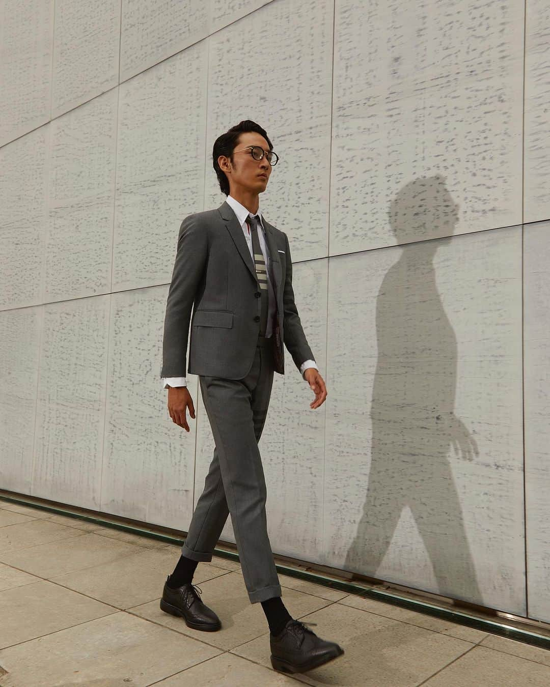 The Fashion Postさんのインスタグラム写真 - (The Fashion PostInstagram)「#fashion THOM BROWNE with  Shuhei Uesugi 『自分らしさをまとうユニフォーム。上杉柊平とトム ブラウン〈前編〉』  2003年、ニューヨークにあるオーダーメイドの店で5着のスーツからスタートした THOM BROWNE (トム ブラウン)。アメリカン・トラッドをモダンに再構築したピースには、着こなし方にも厳格なルールが定められ、細部にいたるまで彼の美学が垣間見える。グレーを基調に、スリムなジャケット、アンクル部分を折り返したトラウザー、4本線をあしらったカーディガン、ホワイトのオックスフォードシャツ、ネクタイ、そして革靴。「ユニフォーミティー (画一性) が真の個性を、真の自信を示している」と語る彼は、現代におけるユニフォームであるスーツに新たな息吹をもたらした。  話題のドラマや映画に立て続けに出演し、俳優として躍進を続けながらも、今年3月に惜しまれつつも解散したヒップホップクルー KANDYTOWN (キャンディタウン) の Holly Q (ホーリー キュー) としてラッパーの顔もあわせ持つ上杉柊平が、THOM BROWNE の定番コレクションを纏い、自分らしさを表現する。(第1回/全2回)。  model: Shuhei Uesugi photography: Toshio Ohno styling: Yoko Irie hair: Kazuma Kimura make up: Shiho Sakamoto text: Manaha Hosoda & Risa Matsumoto edit: Risa Matsumoto & Shiyori Kawamura  #tfp #thefashionpost #thombrowne #トムブラウン #上杉柊平 #Shuheiuesugi #pr」11月6日 18時00分 - tfpjp