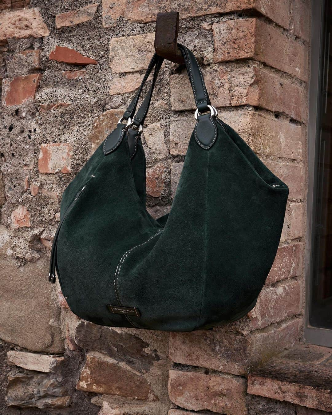 ジャンニキアリーニのインスタグラム：「Soft suede leather, moon shape, maxi side pockets and minimal design. Violante is a handbag with a chic charm and practical attitude.  #giannichiarini #gc #ジャンニキアリーニ #fw23」