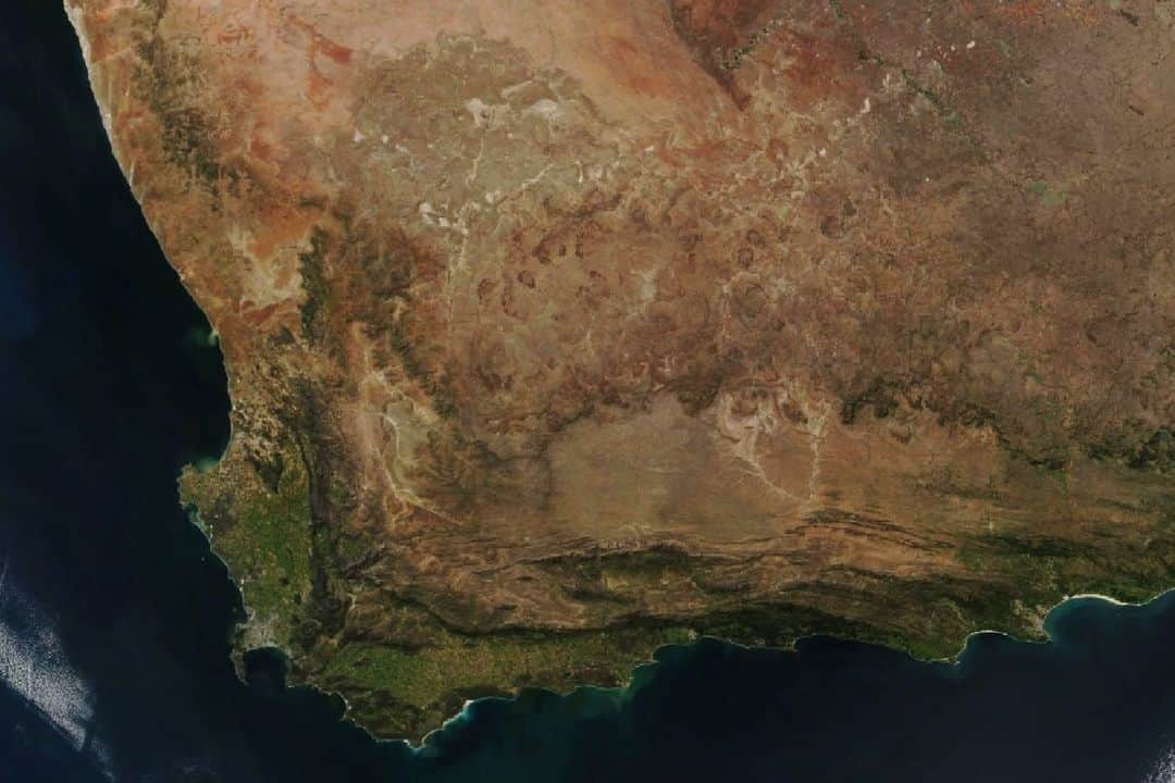 NASAのインスタグラム：「Biodiversity is popping in South Africa’s Greater Cape Floristic Region. This Suomi NPP image shows a satellite view of the region. The map shows the outline of the smallest of Earth's six floral kingdoms.  Image description 1: An aerial satellite image of The Greater Cape Floristic Region in South Africa. The ocean is a dark blue and the land is orange with green along the southernmost edges.  Image description 2: Map of The Greater Cape Floristic Region in South Africa. The ocean is a light blue and the Greate Cape Floristic Region is green with an outline along the southernmost edge.」