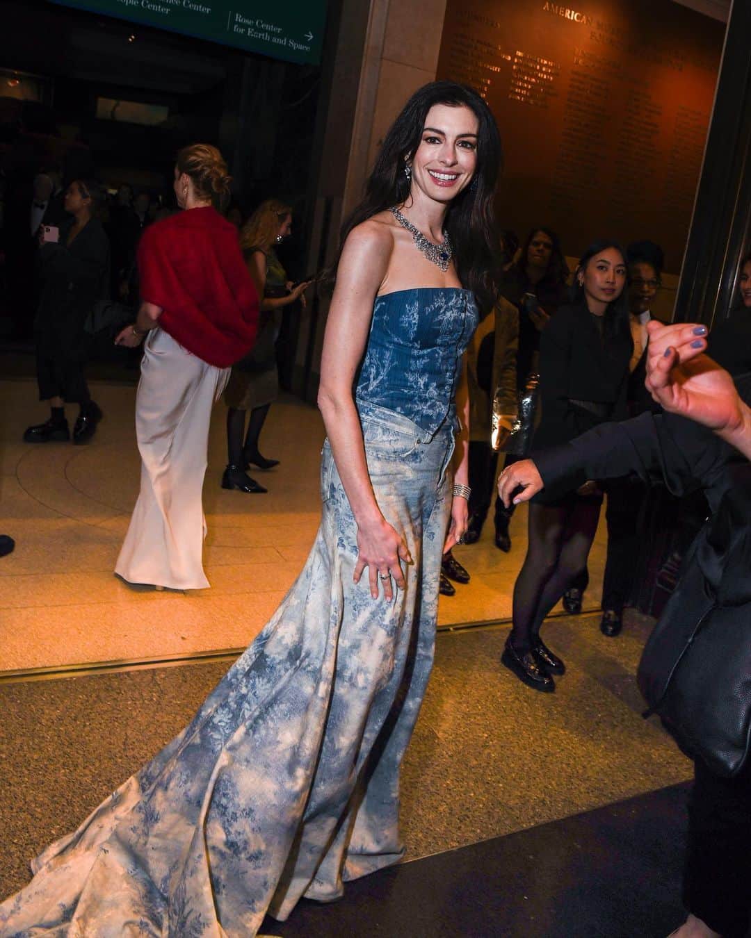 のインスタグラム：「#AnneHathaway hosted the 2023 #CFDAAwards last night and delivered not one, but two memorable red-carpet looks. Beginning the night in head-to-toe denim, she paired a light-wash, floral-printed corset and skirt by @RalphLauren with blinding diamond jewellery. Later, for the ceremony, she swapped into a red floral @Rodarte gown from the house’s SS18 collection. Click the link in bio for all the details on her eveningwear.」